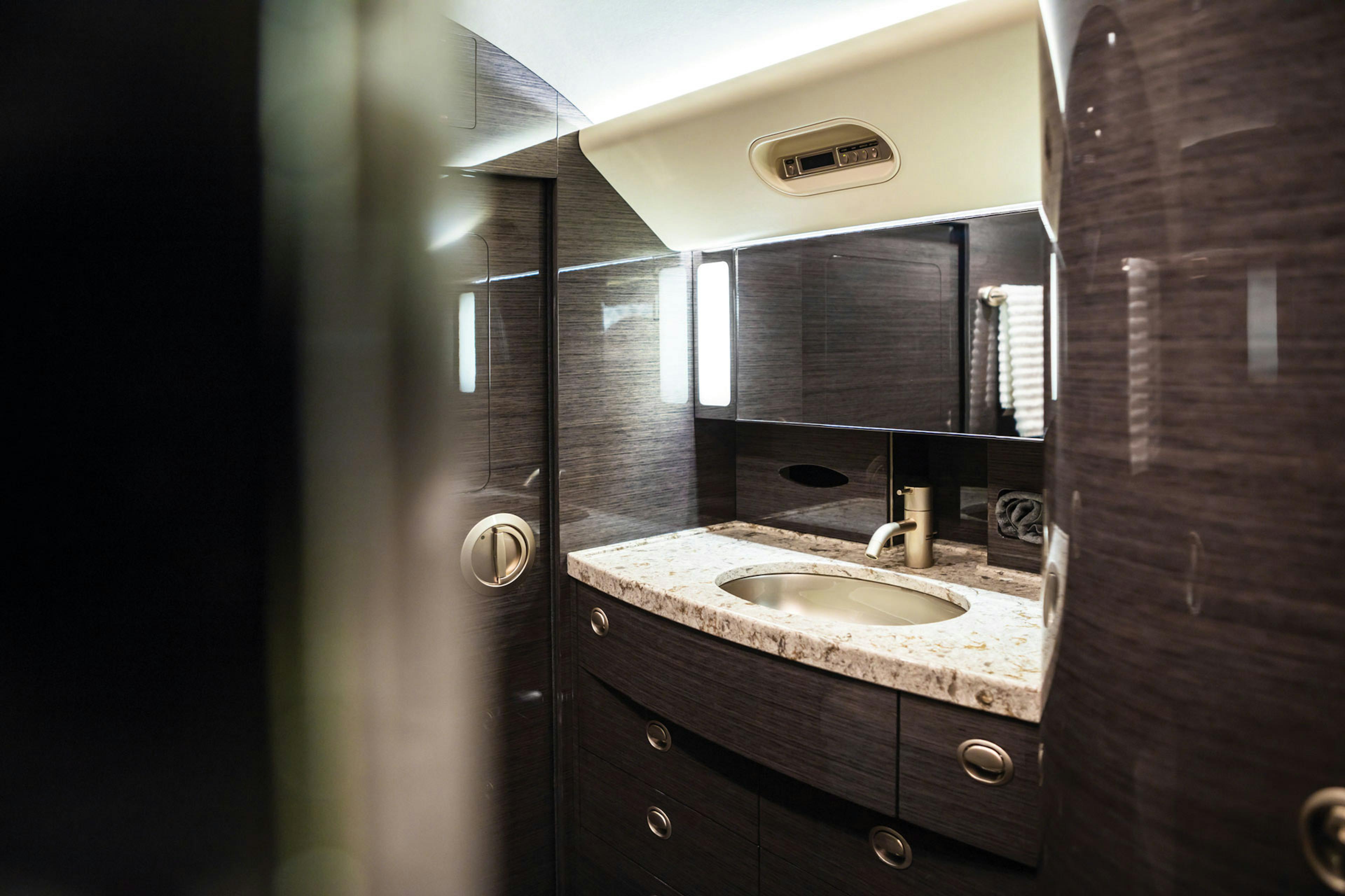 The bathroom area highlighted with dark shiny wood cabinets