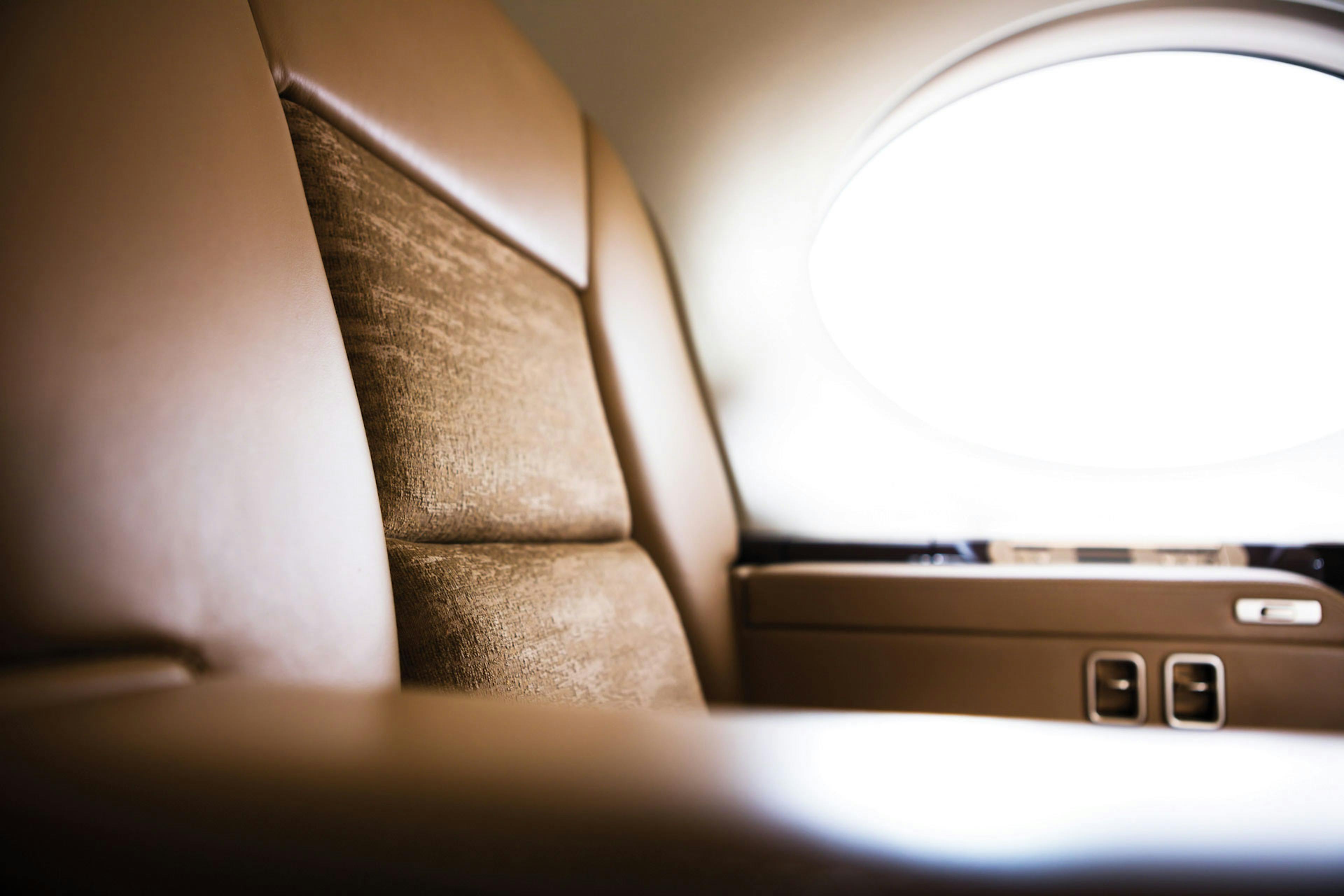Close up of the custom tan leather and inlay for the seat by an illuminated window