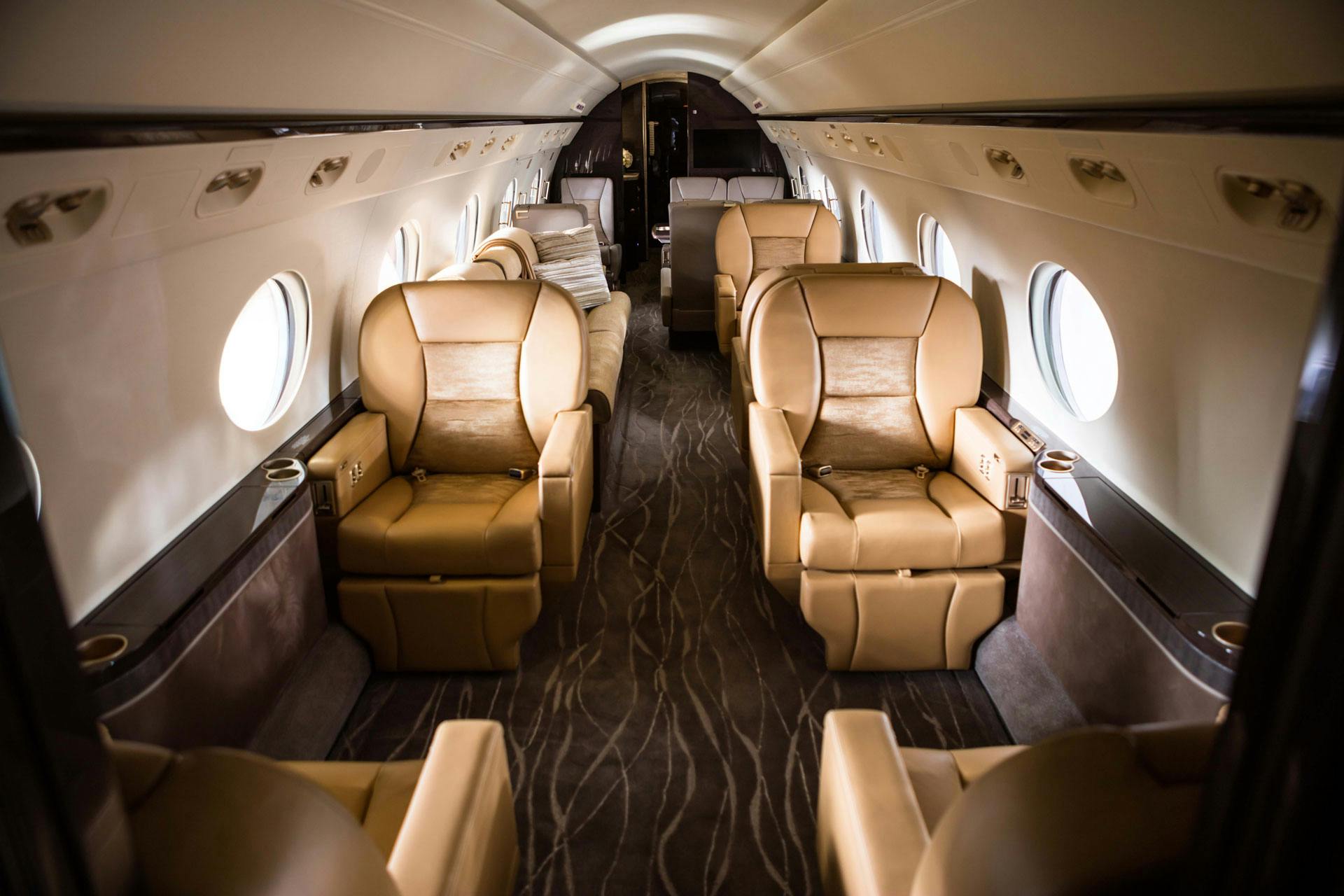 Custom tan leather seats and patterned carpet in the cabin of the aircraft