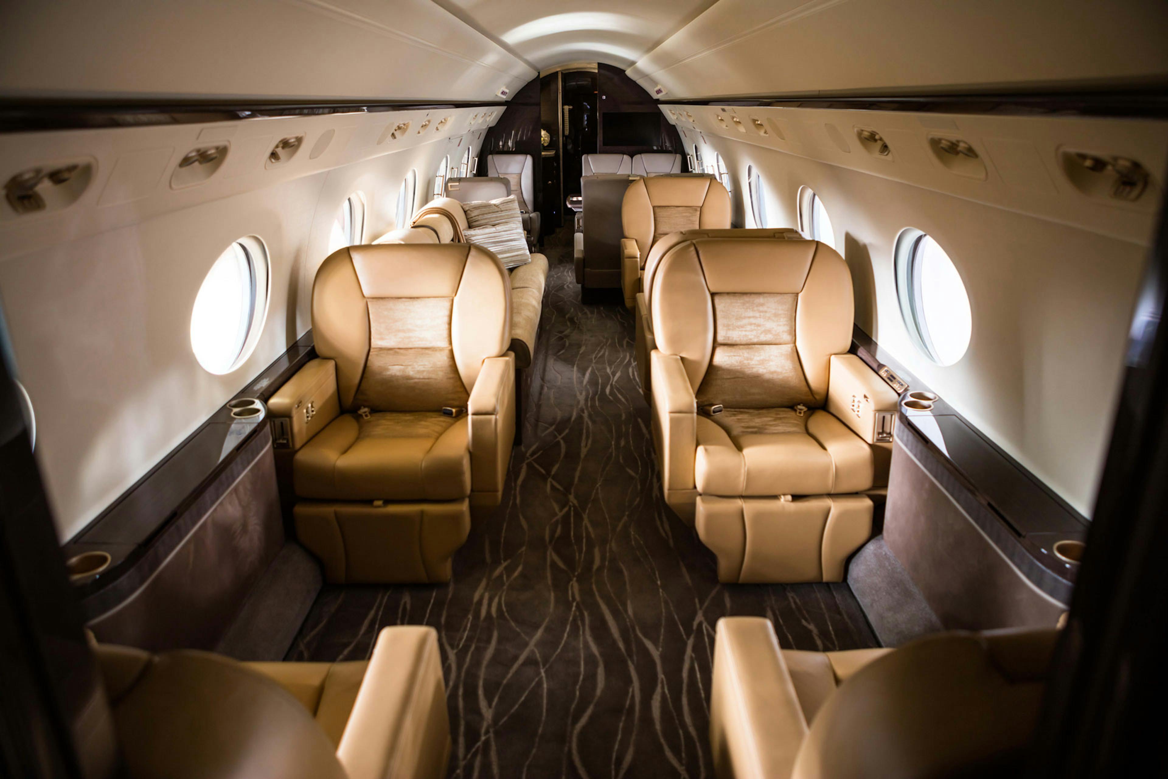 Custom tan leather seats and patterned carpet in the cabin of the aircraft