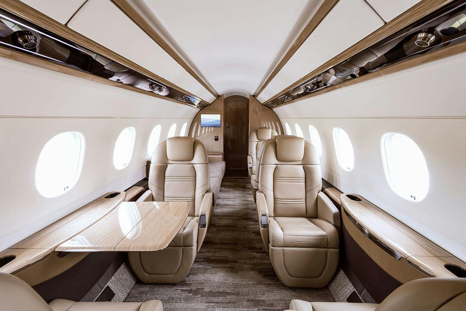tan seats and an extended out table in the interior of an aircraft