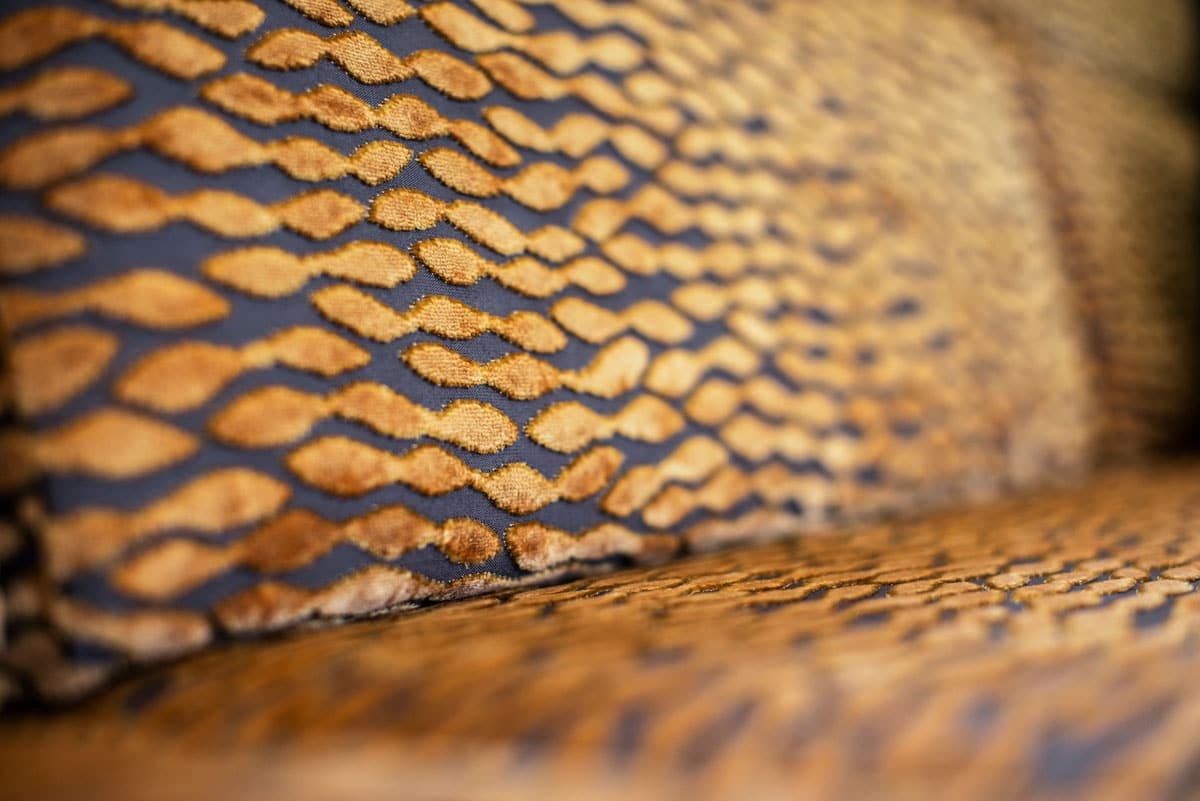 Inside the Praetor 500, focused up on the fabric of the sofa with its pattern of golden yellow spots on top of black.