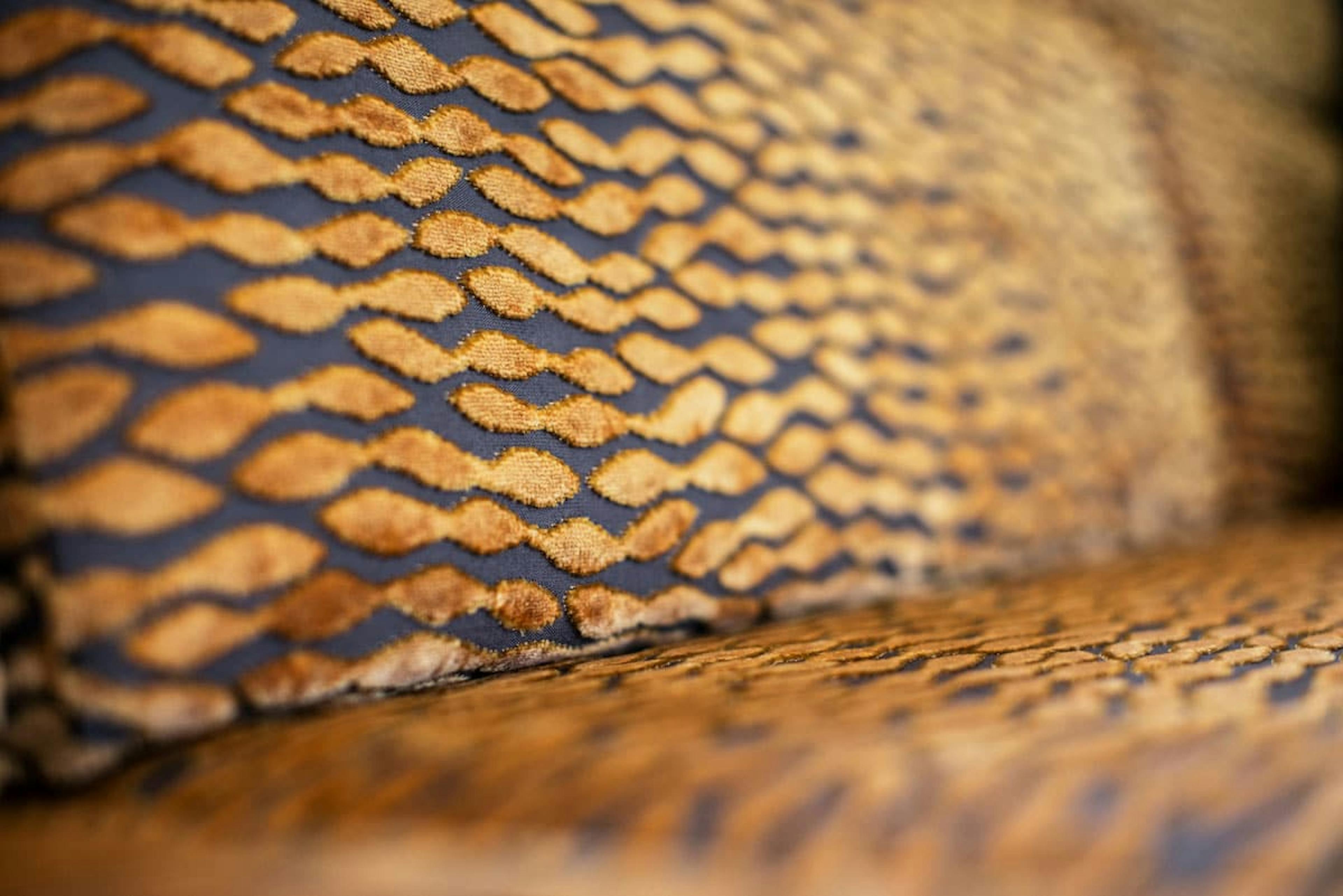 Inside the Praetor 500, focused up on the fabric of the sofa with its pattern of golden yellow spots on top of black.