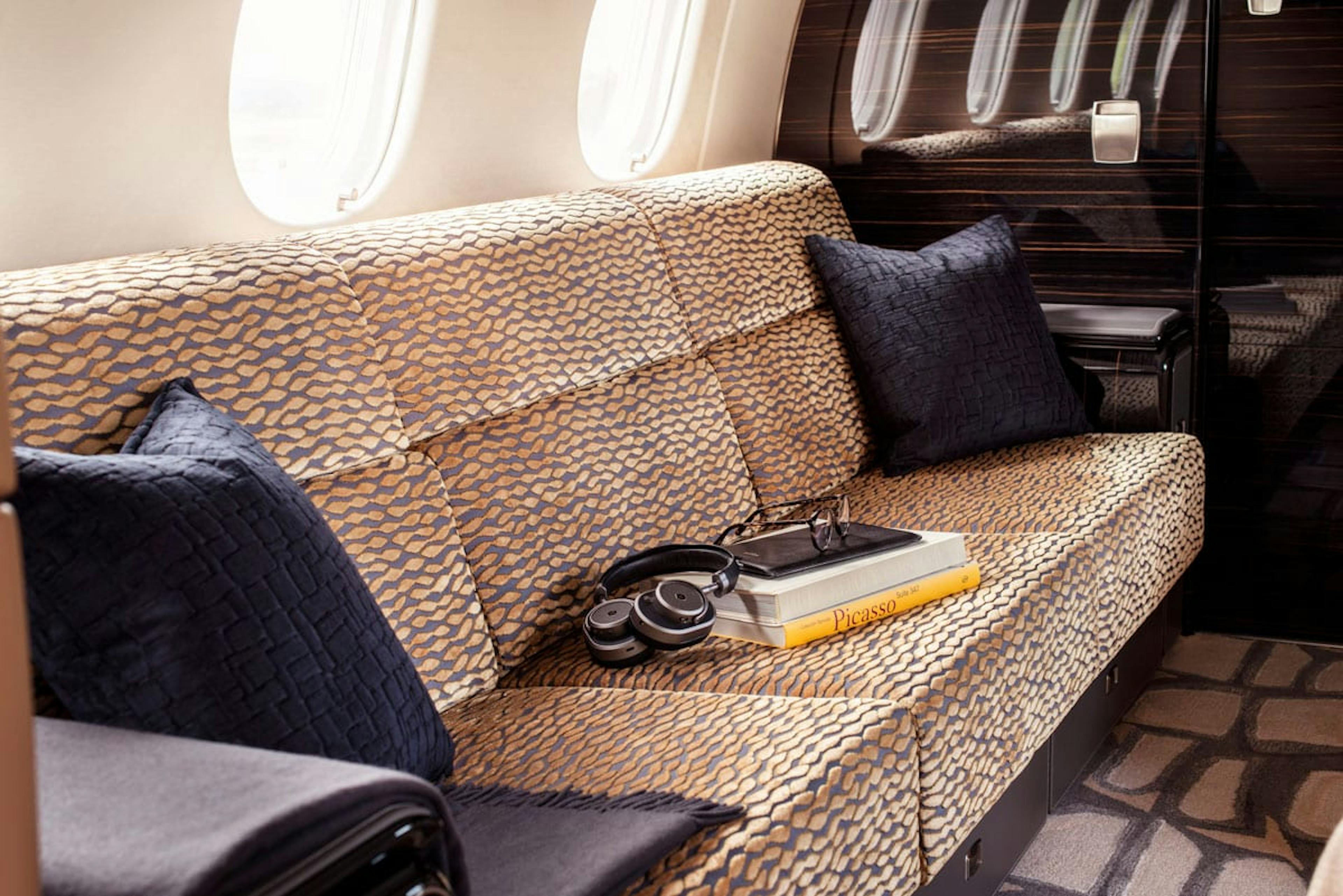 Inside the Praetor 500, focused on the unique print on the sofa along with pillows and other items resting on the couch