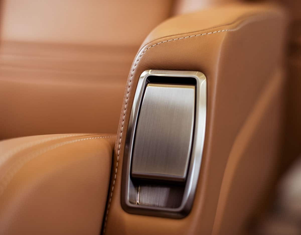 Inside the Praetor 500, focused on the recliner button and caramel colored leather seats