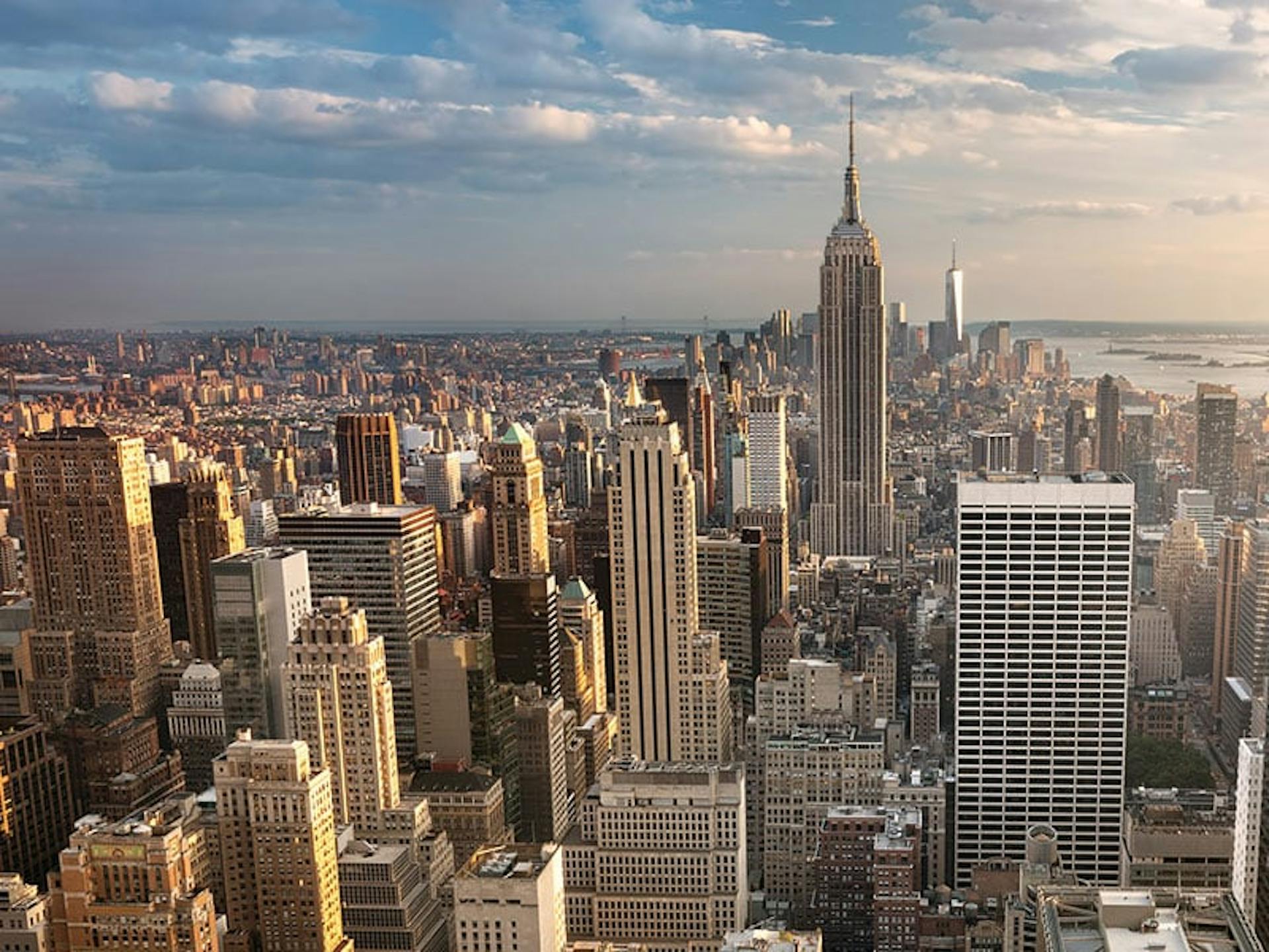 A city skyline,  looking at many tall buildings and slightly cloudy blue skies 