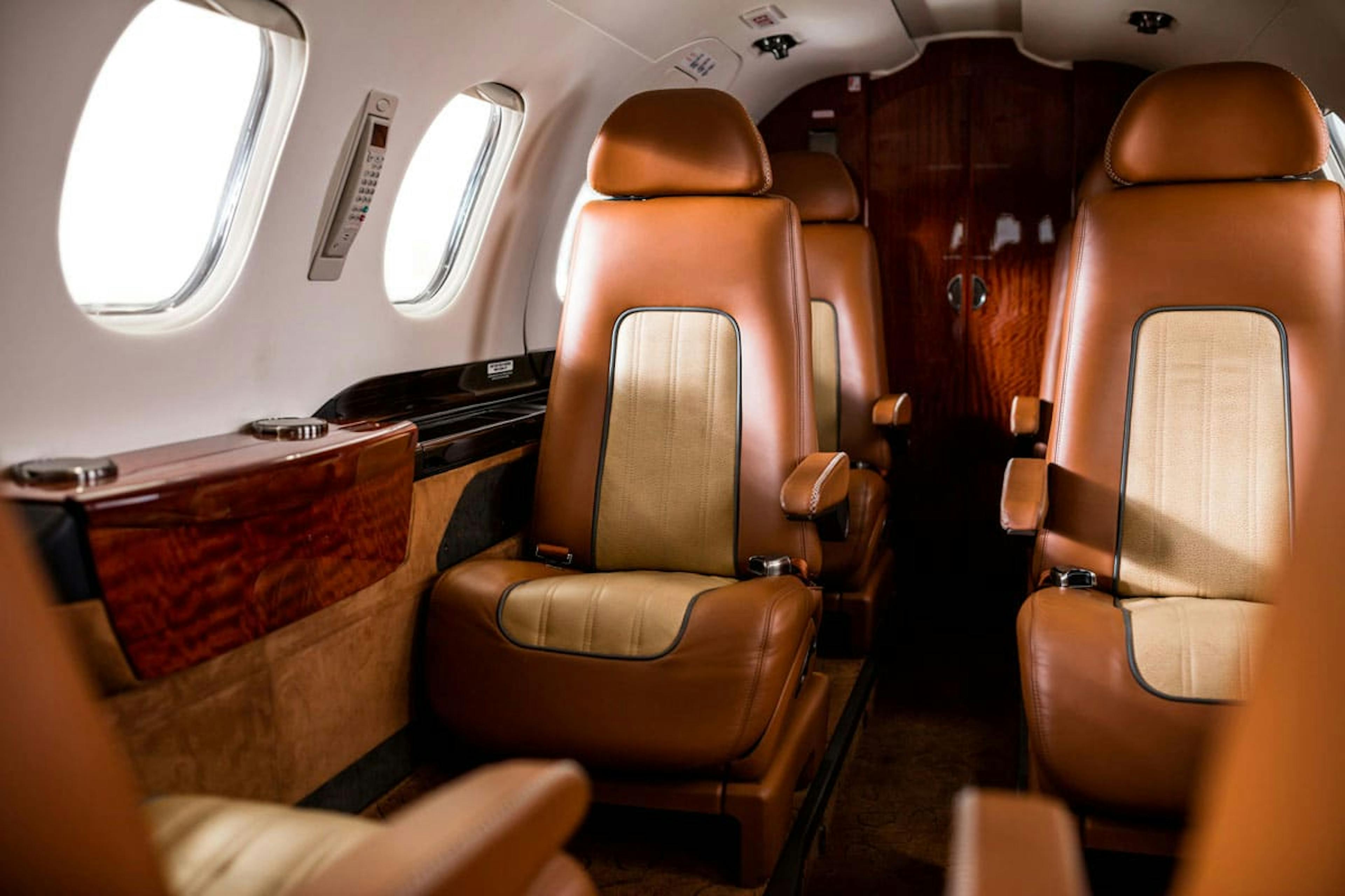 Quality interior of the Phenom 300, focused on the beautiful side table and seating at the middle of the cabin
