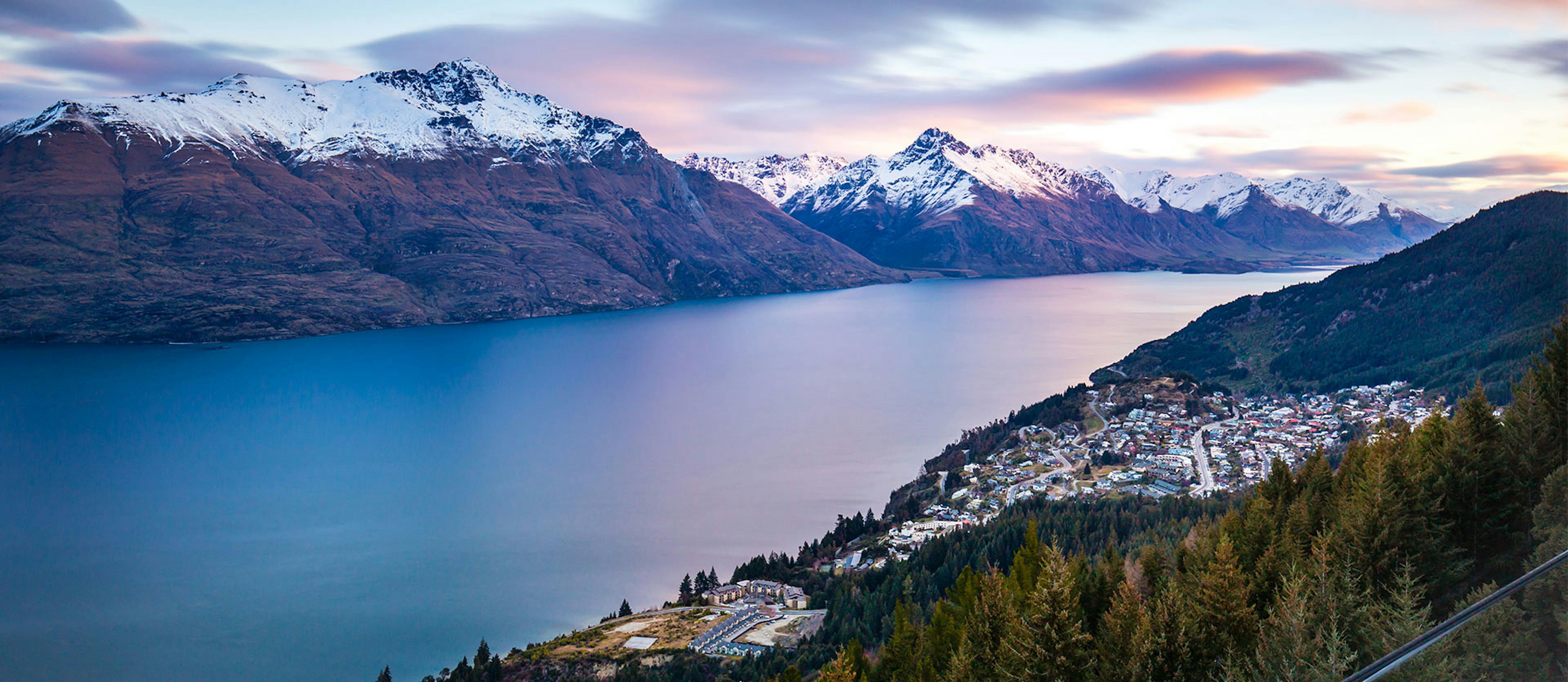 snow capped mountains across a body of water from the town