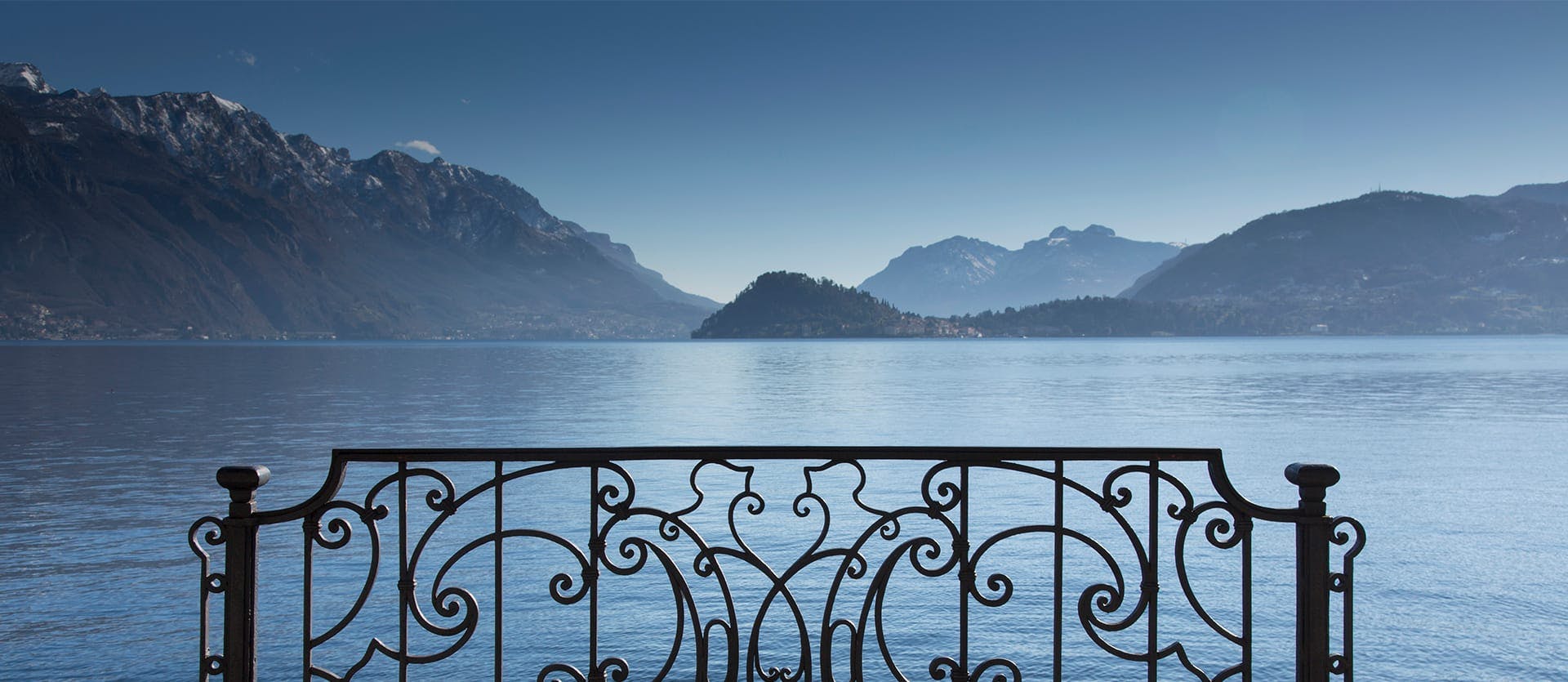 the view of a lake over a detailed railing