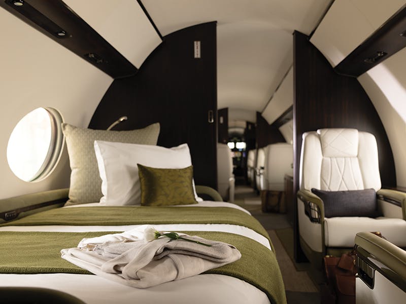 folded items on the day bed of a private jet