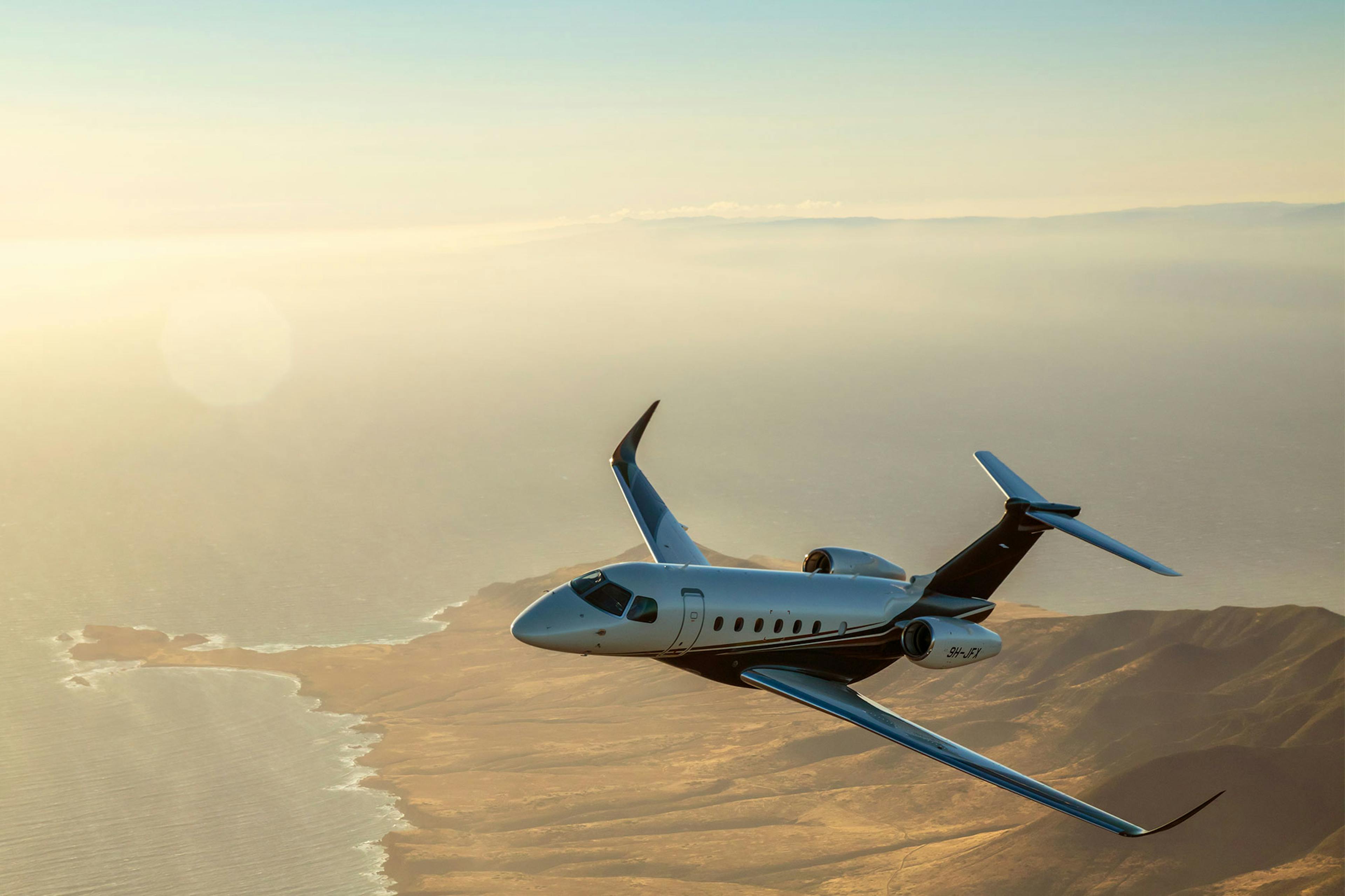 EU version of the jet card hero image featuring a flexjet aircraft over a ridge of land at the reach of water