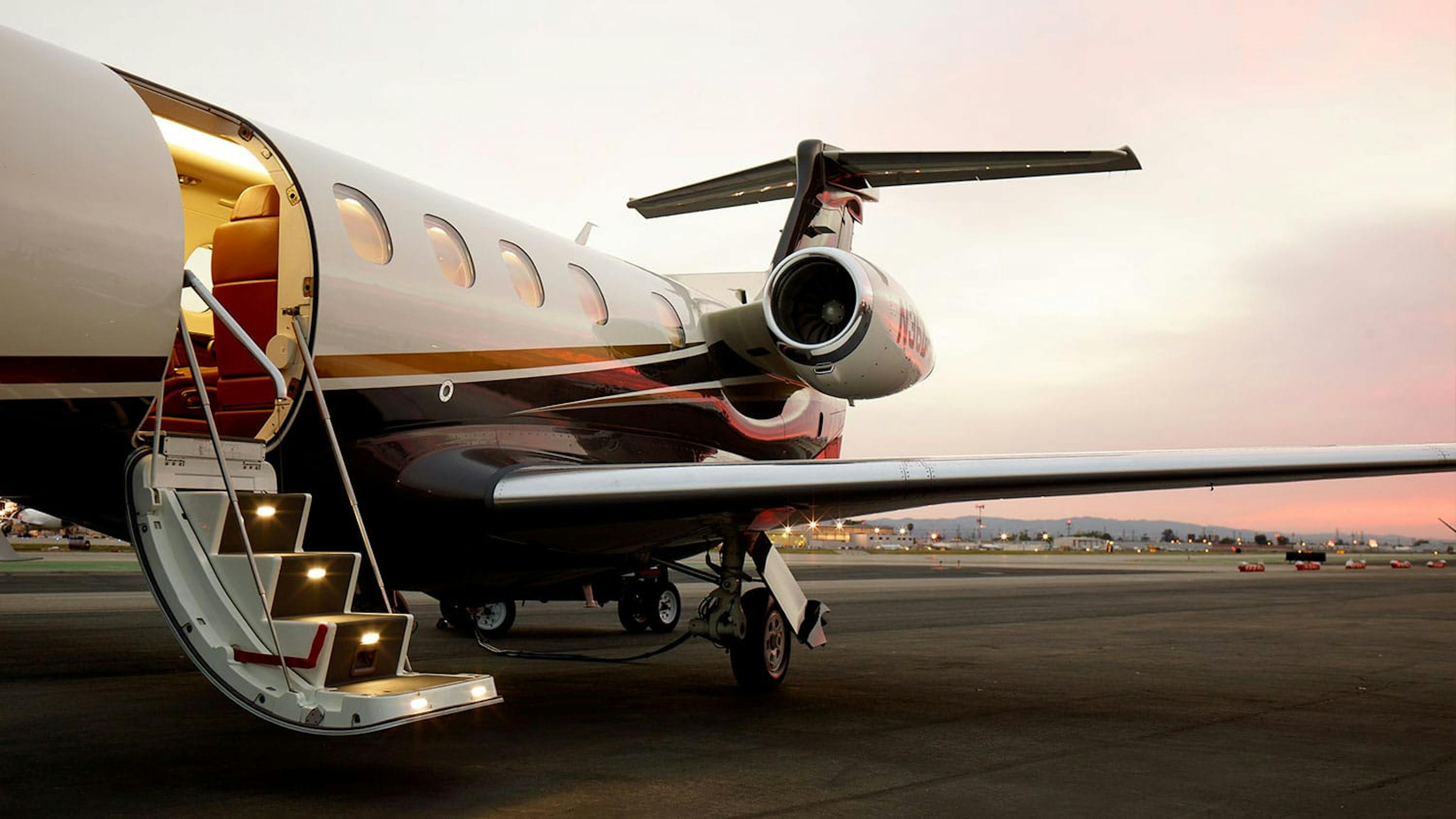 A flexjet aircraft with the stairs deployed sits on the runway 