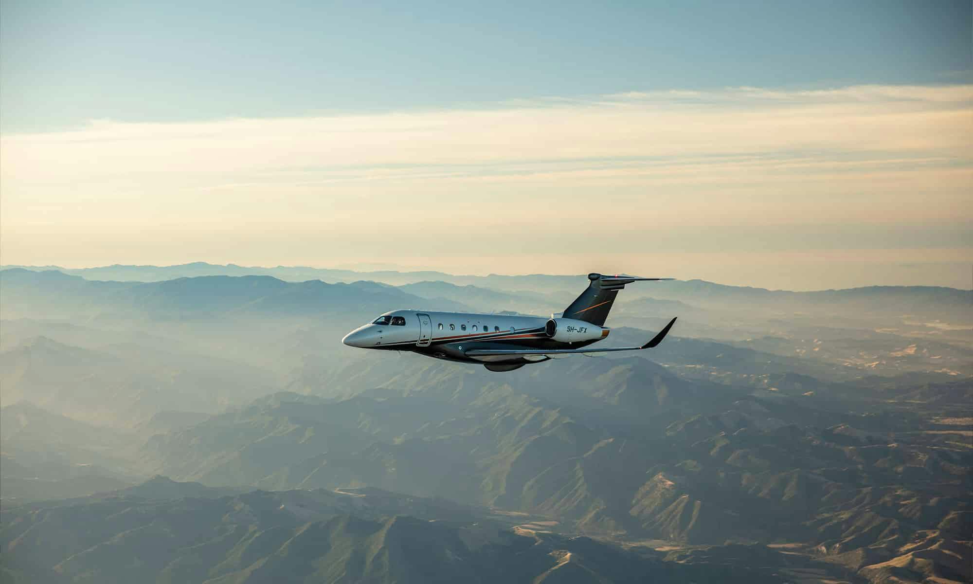 A flexjet aircraft flies over rocky mountains
