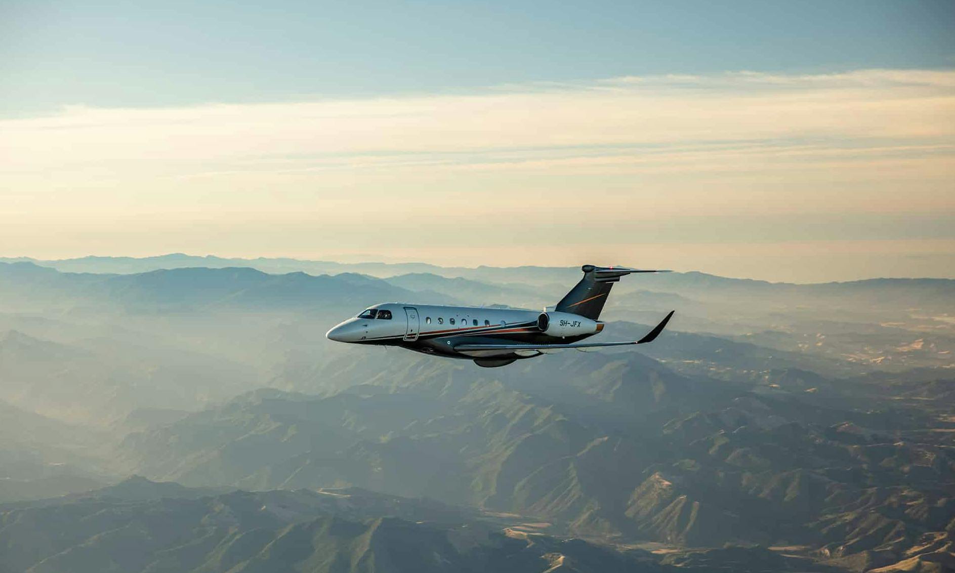 A flexjet aircraft flies over rocky mountains