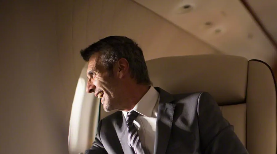 a man sitting in a private jet looking outside the window