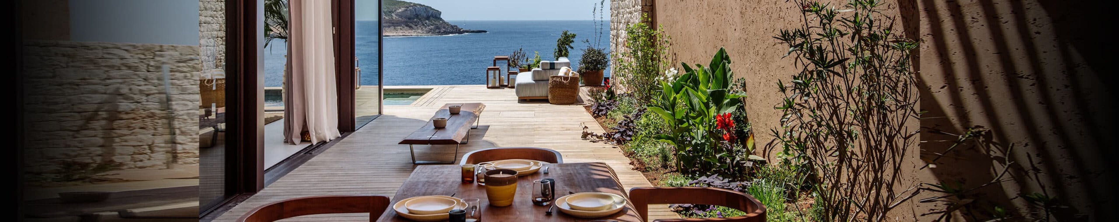 A beautiful courtyard with wood features in the walkway leading to a body of water