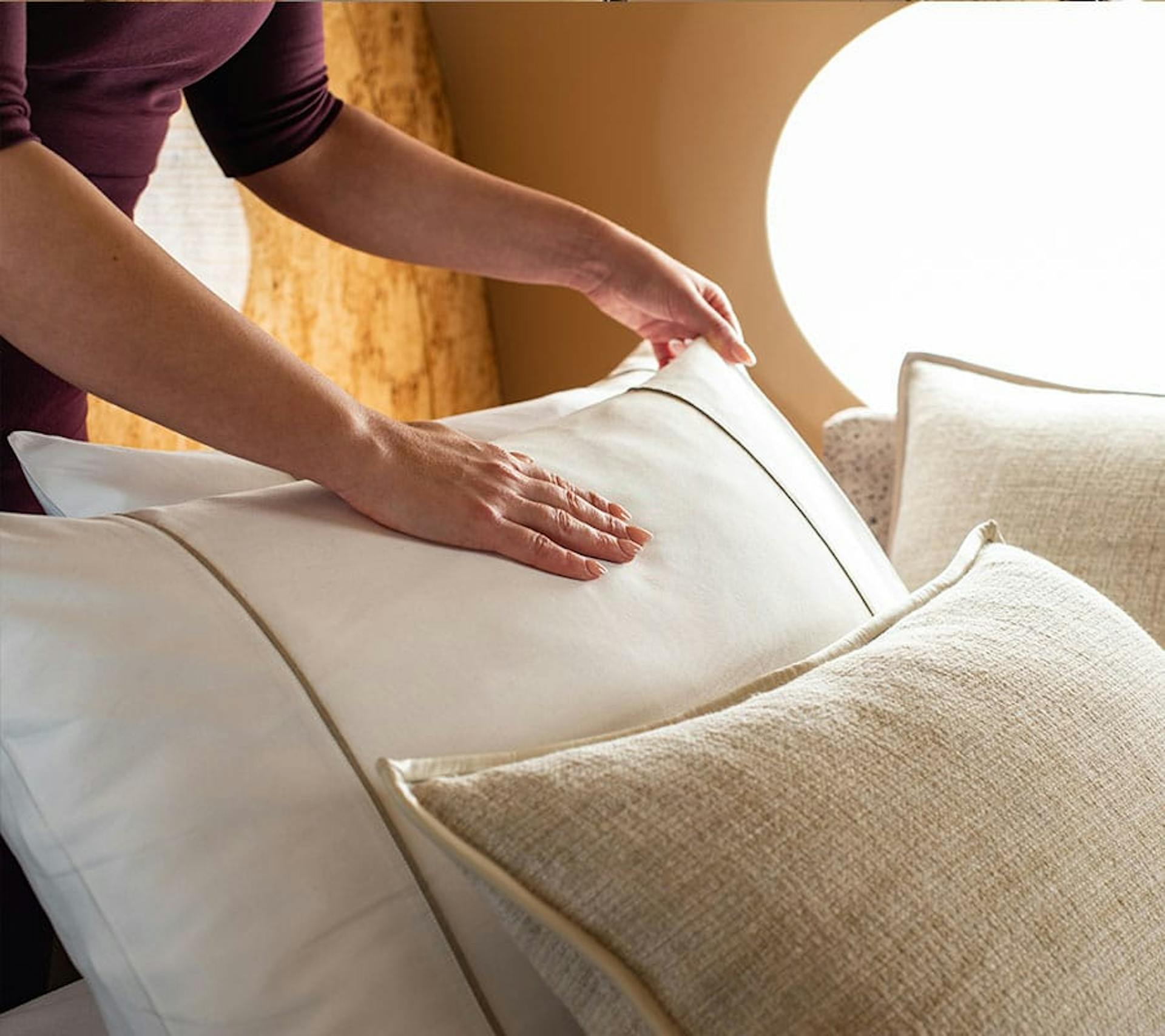 someone setting the pillows on a private jet