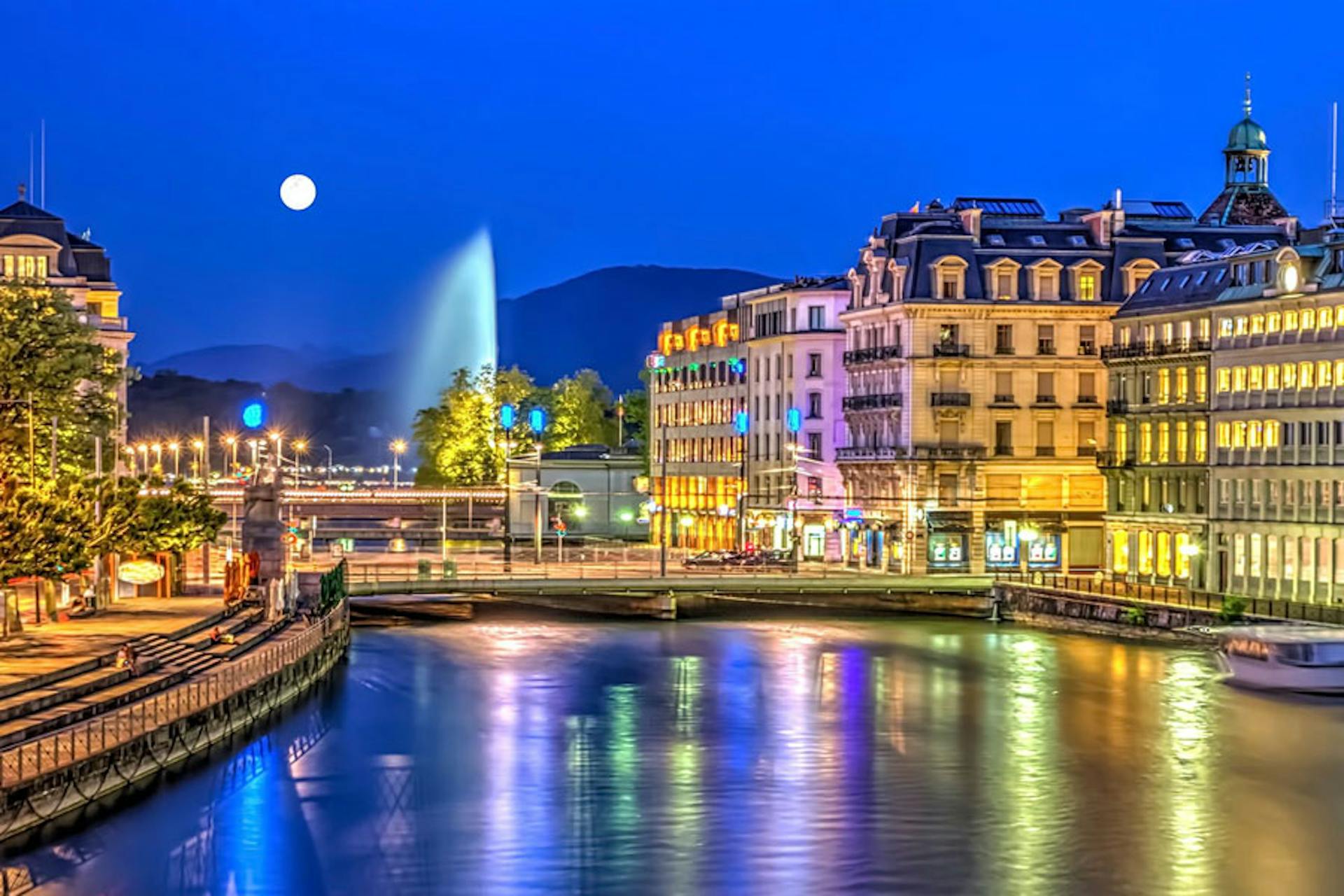 night time with lights reflecting off the water in Geneva