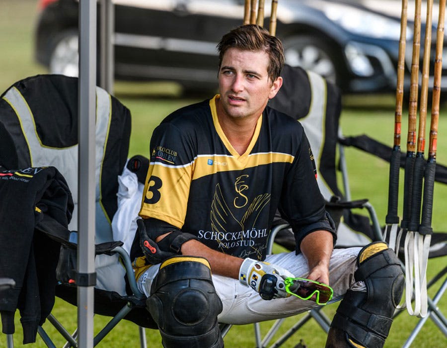 Patrick Maleitzke looking off screen sitting in a foldable outdoor chair