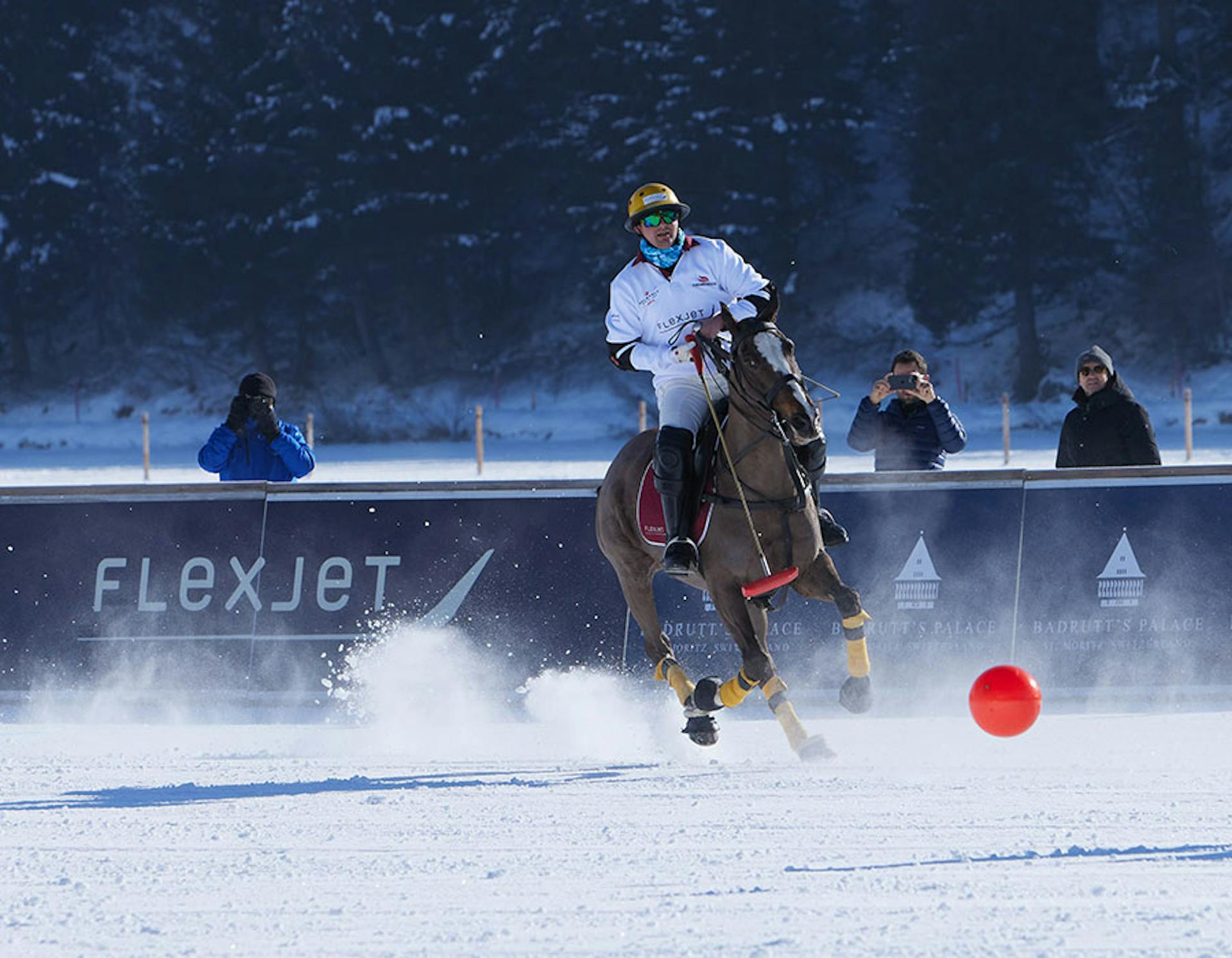 snow polo action shot with flexjet banner in the background