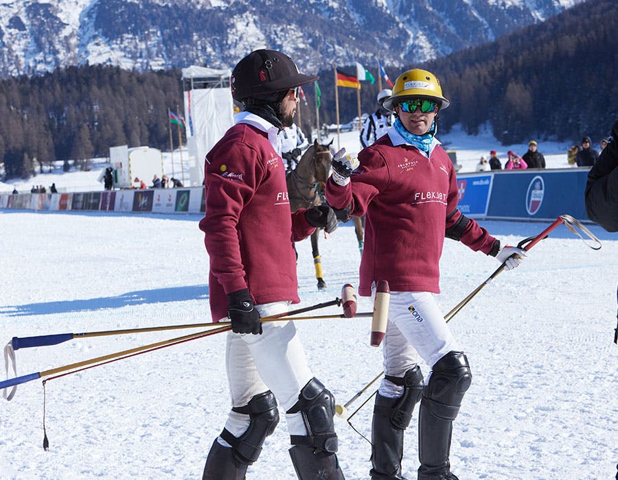 two polo players walking with each other of the course
