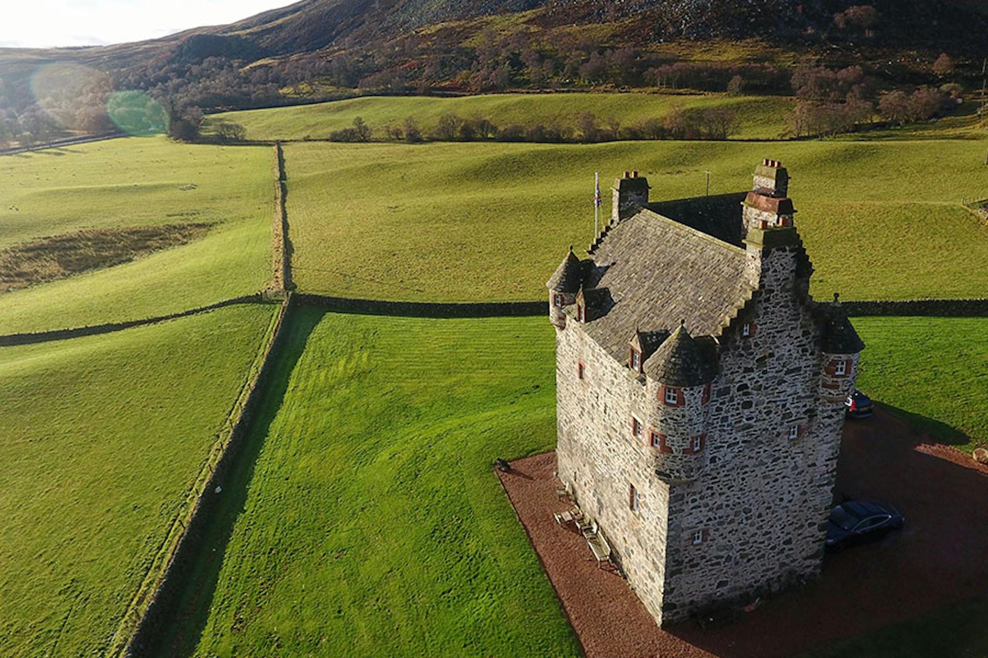 aerial view of mansion and expansive fields of green