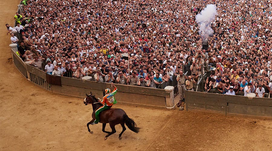 someone riding a horse in front of a large crowd