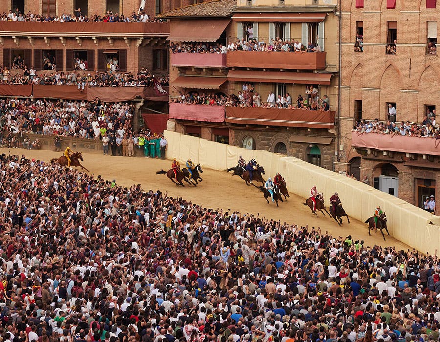 several people racing horses in front of a crowd