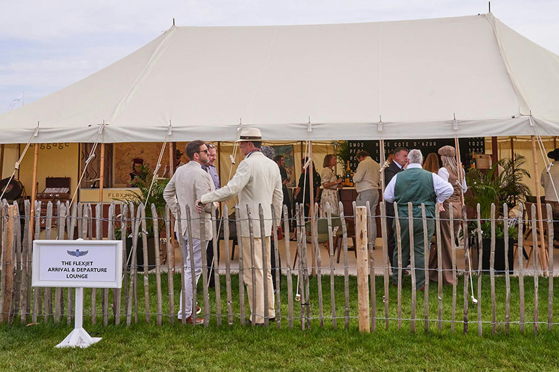 flexjet event tent with people and a fence