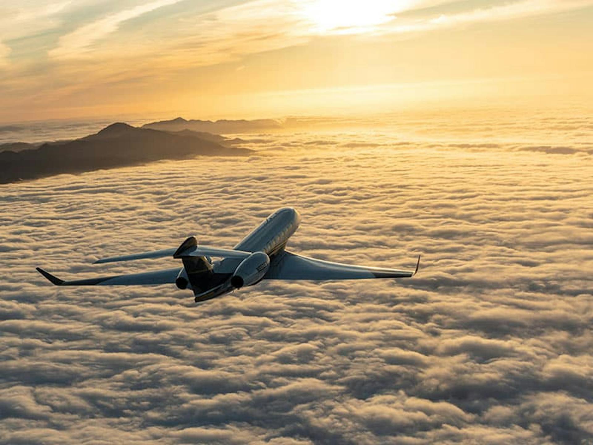 Flexjet aircraft flying over the clouds towards the sunset