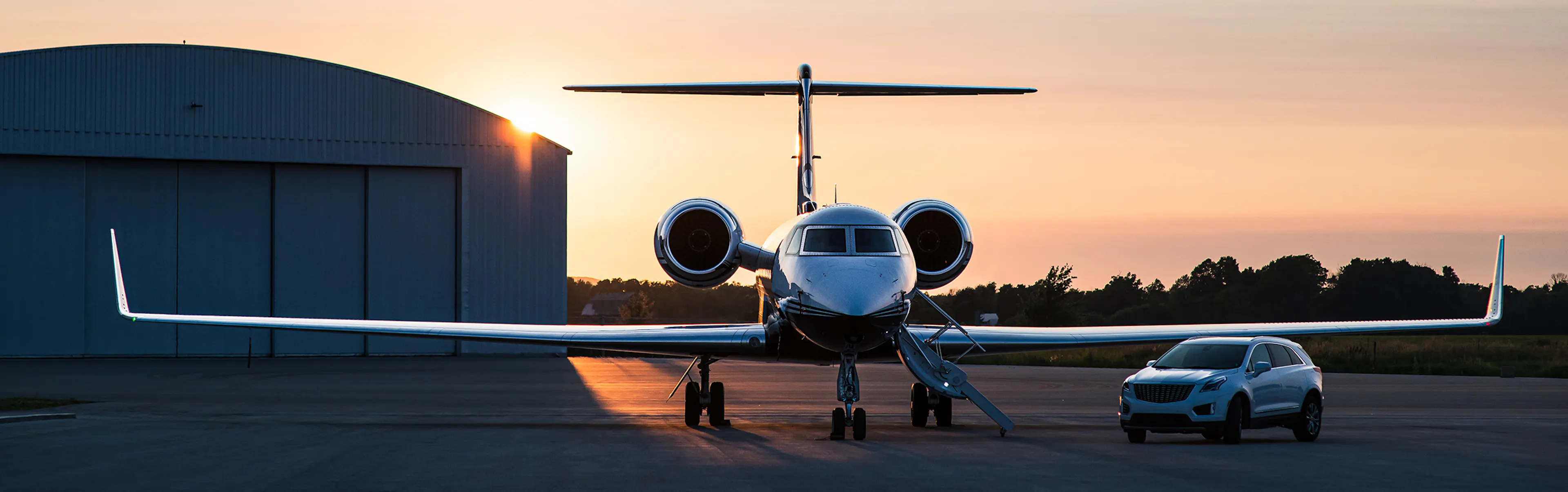 A Flexjet aircraft on the tarmac with a Cadillac auto