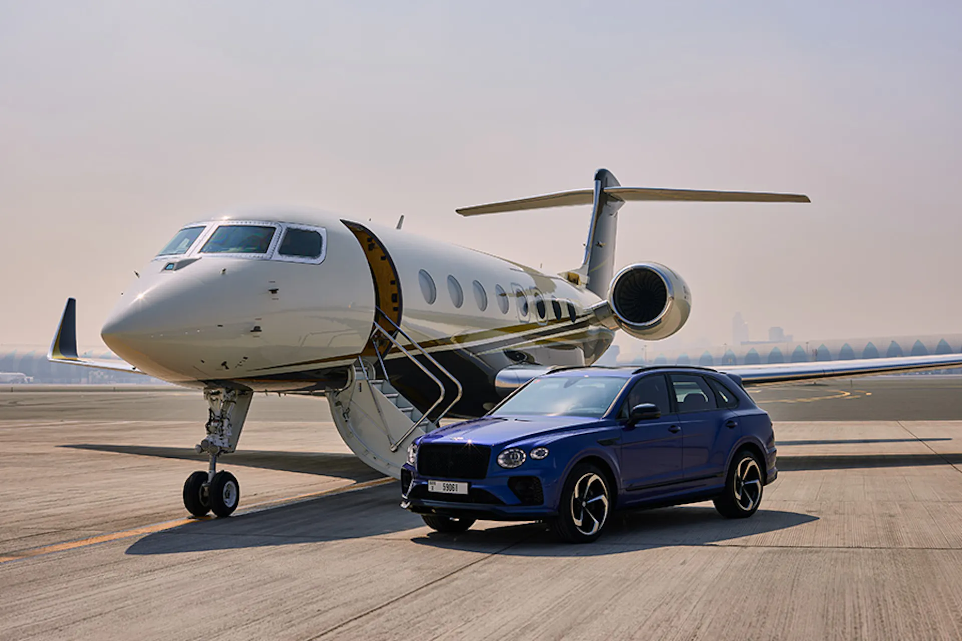 A Flexjet aircraft on the tarmac with a Bentley Bentayga