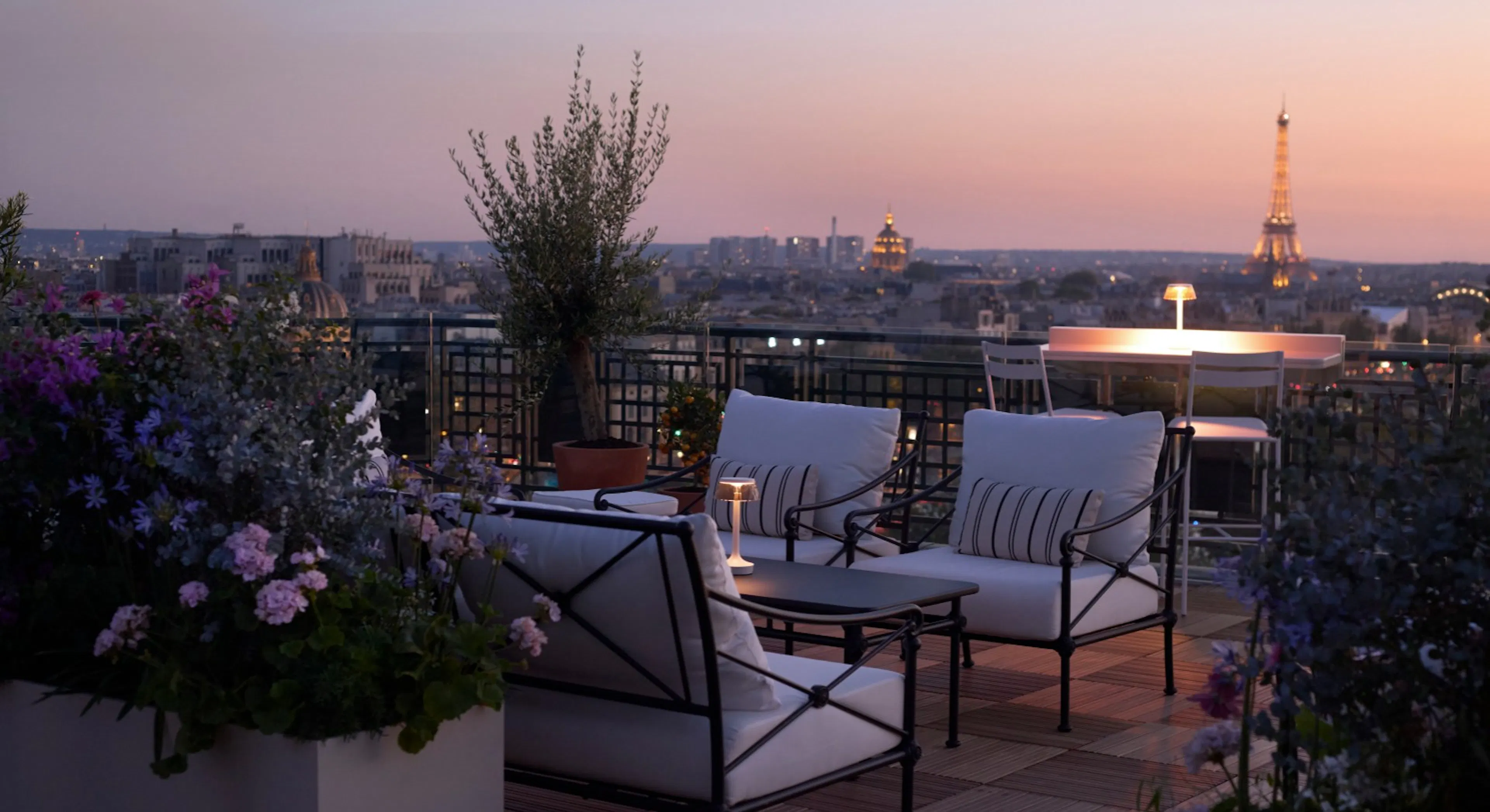 Rooftop patio that overlooks Paris with Eiffel tower illuminated in the background