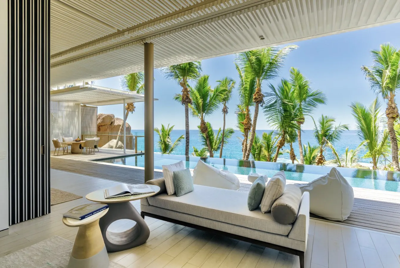 Hotel interior that opens up to infinity pool and view of palm trees and ocean