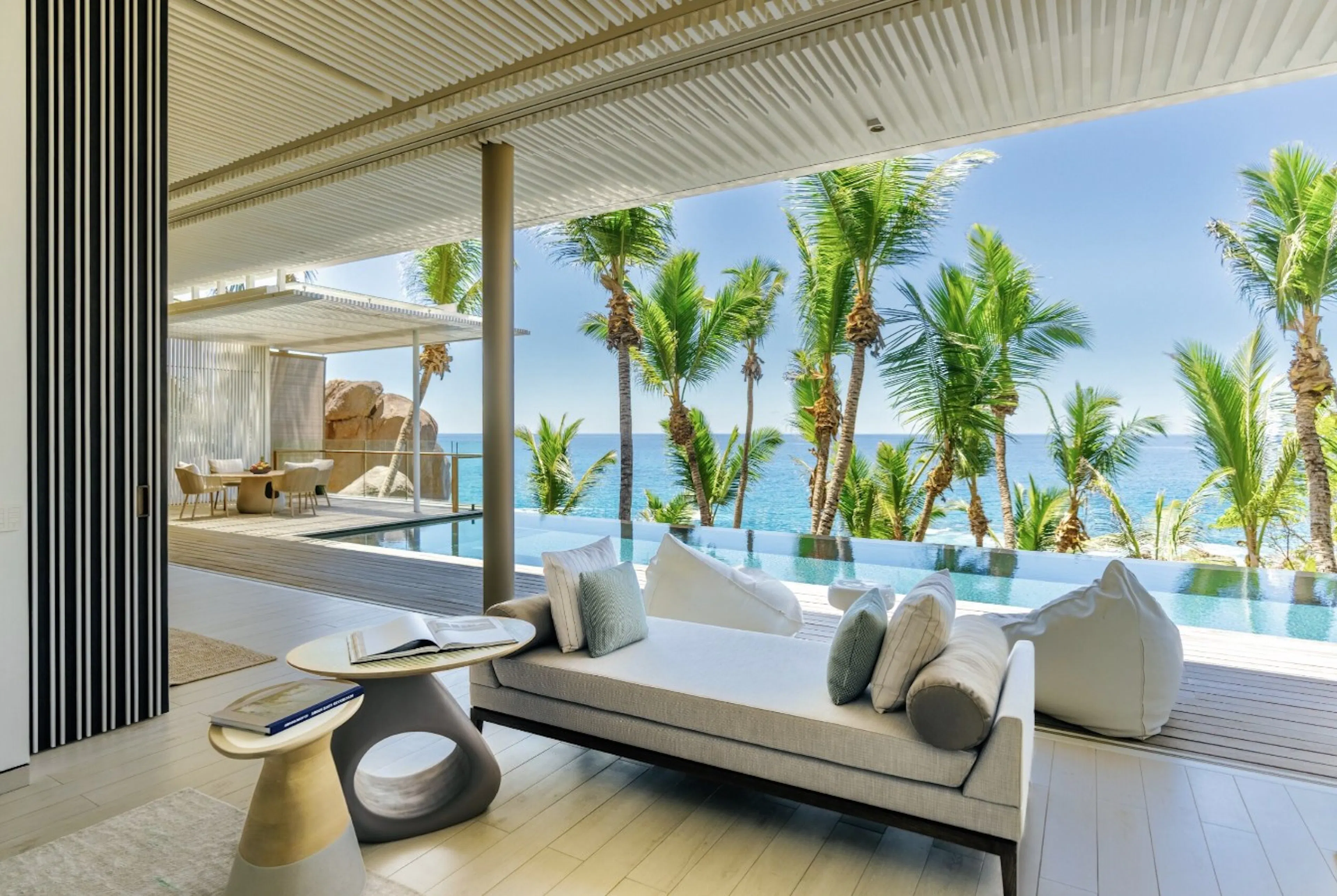 Hotel interior that opens up to infinity pool and view of palm trees and ocean