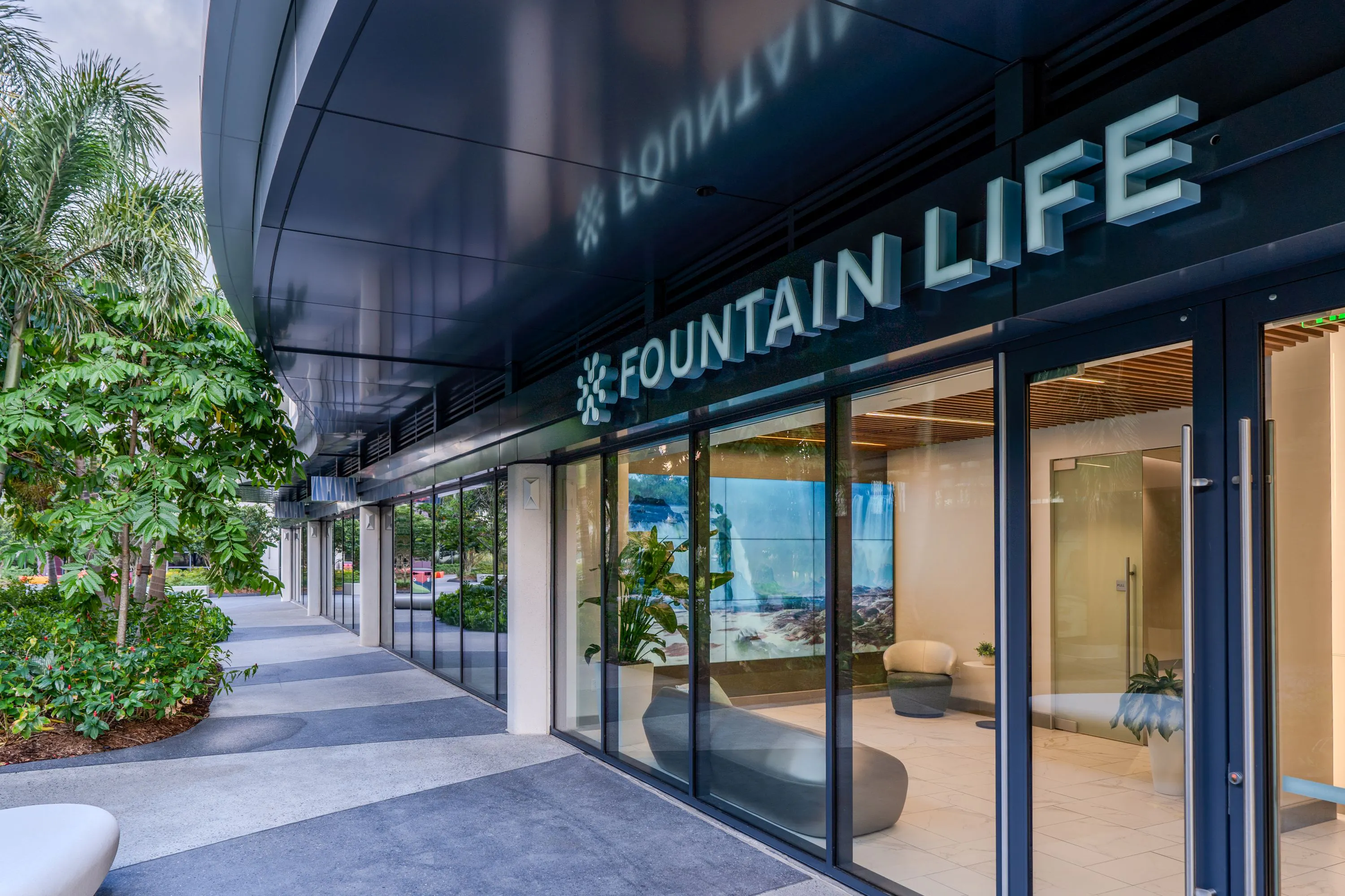 The outside of the Fountain Life building with glass doors allowing a view inside