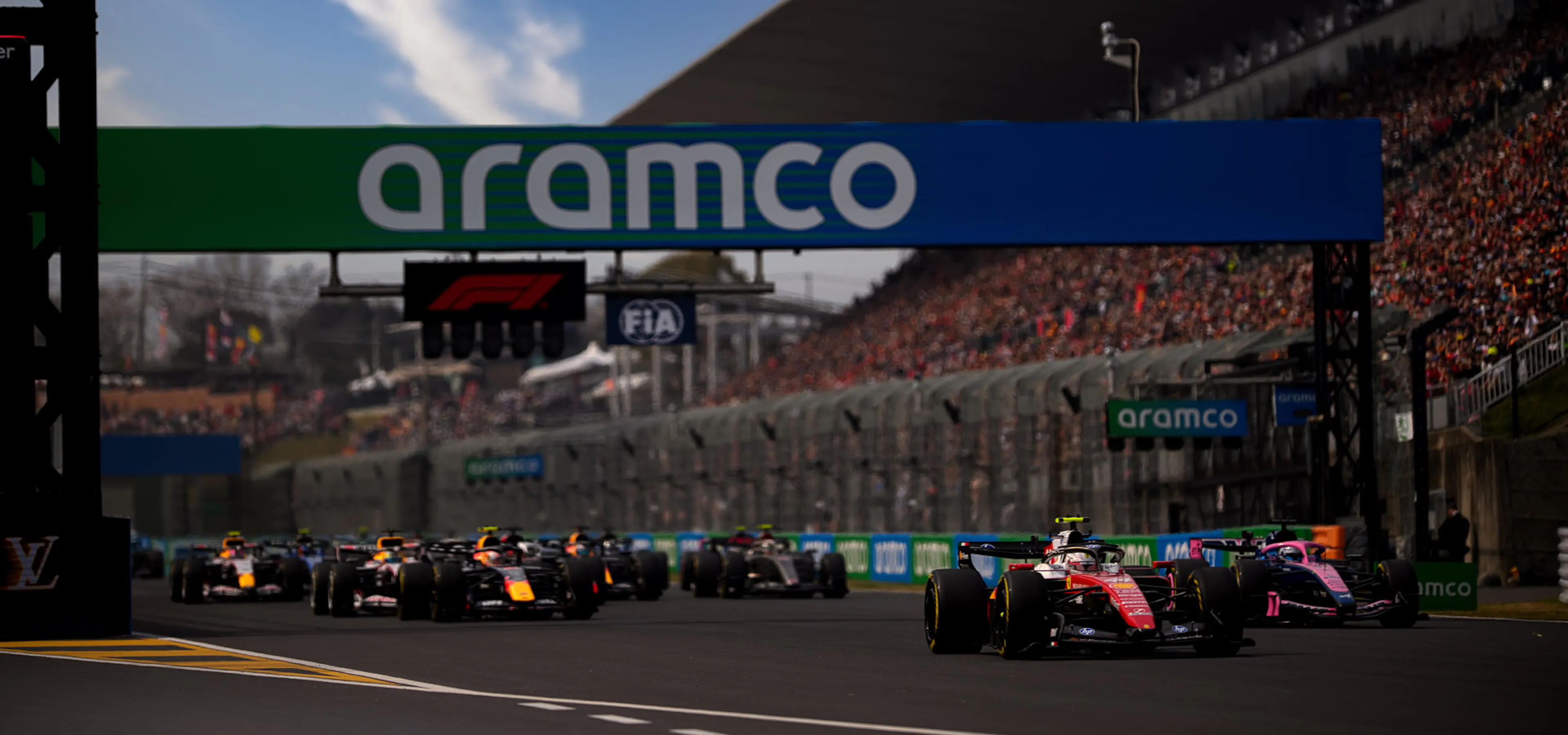 F1 cars racing beneath a banner that says Aramco