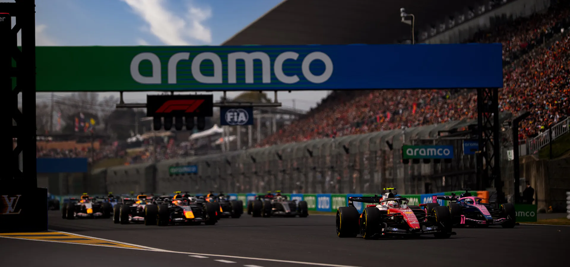 F1 cars racing beneath a banner that says Aramco