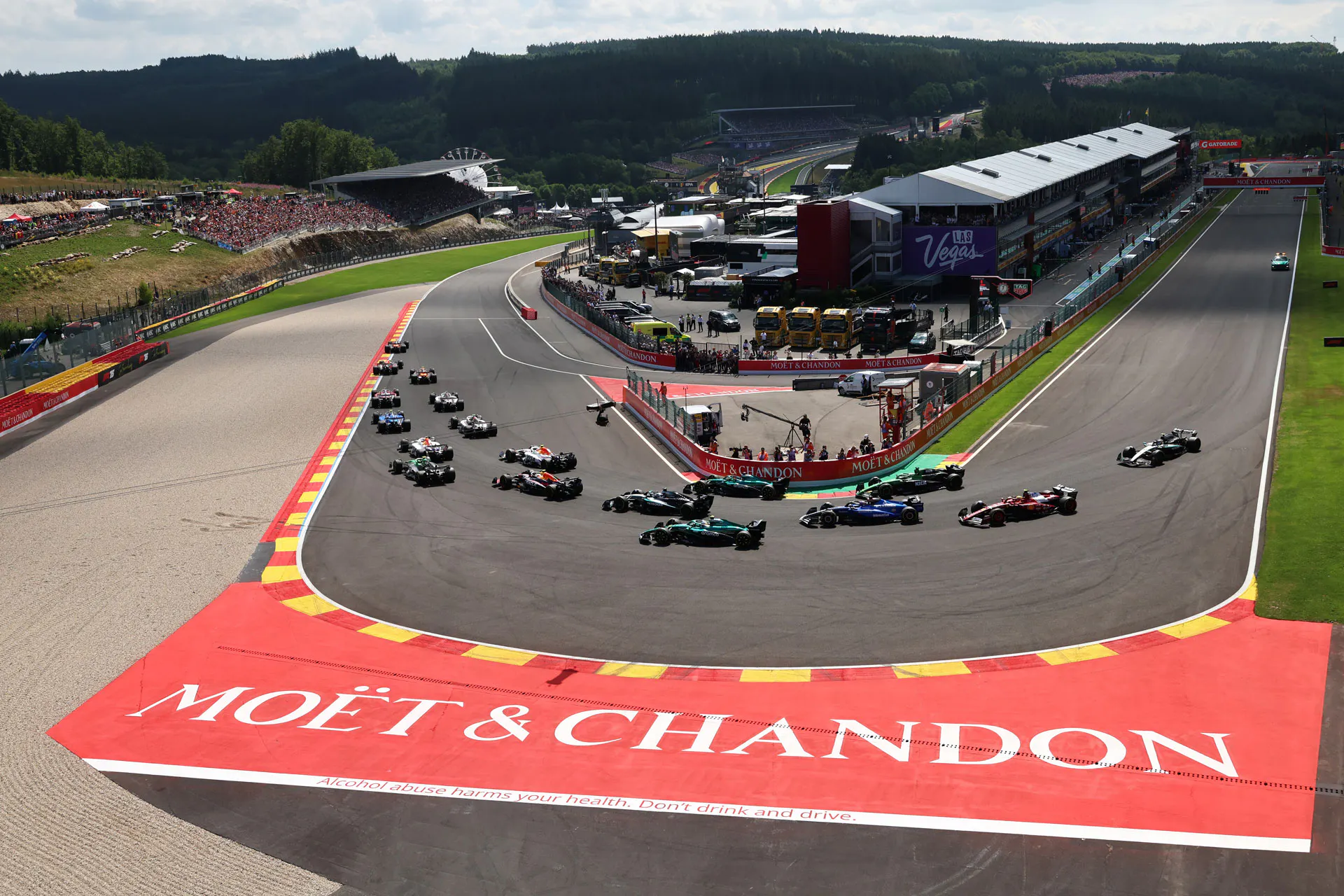 F1 cars rounding a hairpin heading right to left