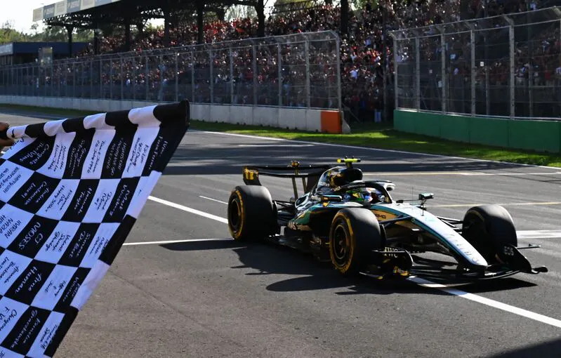 checkered flag waving as the F1 car passes the finish line