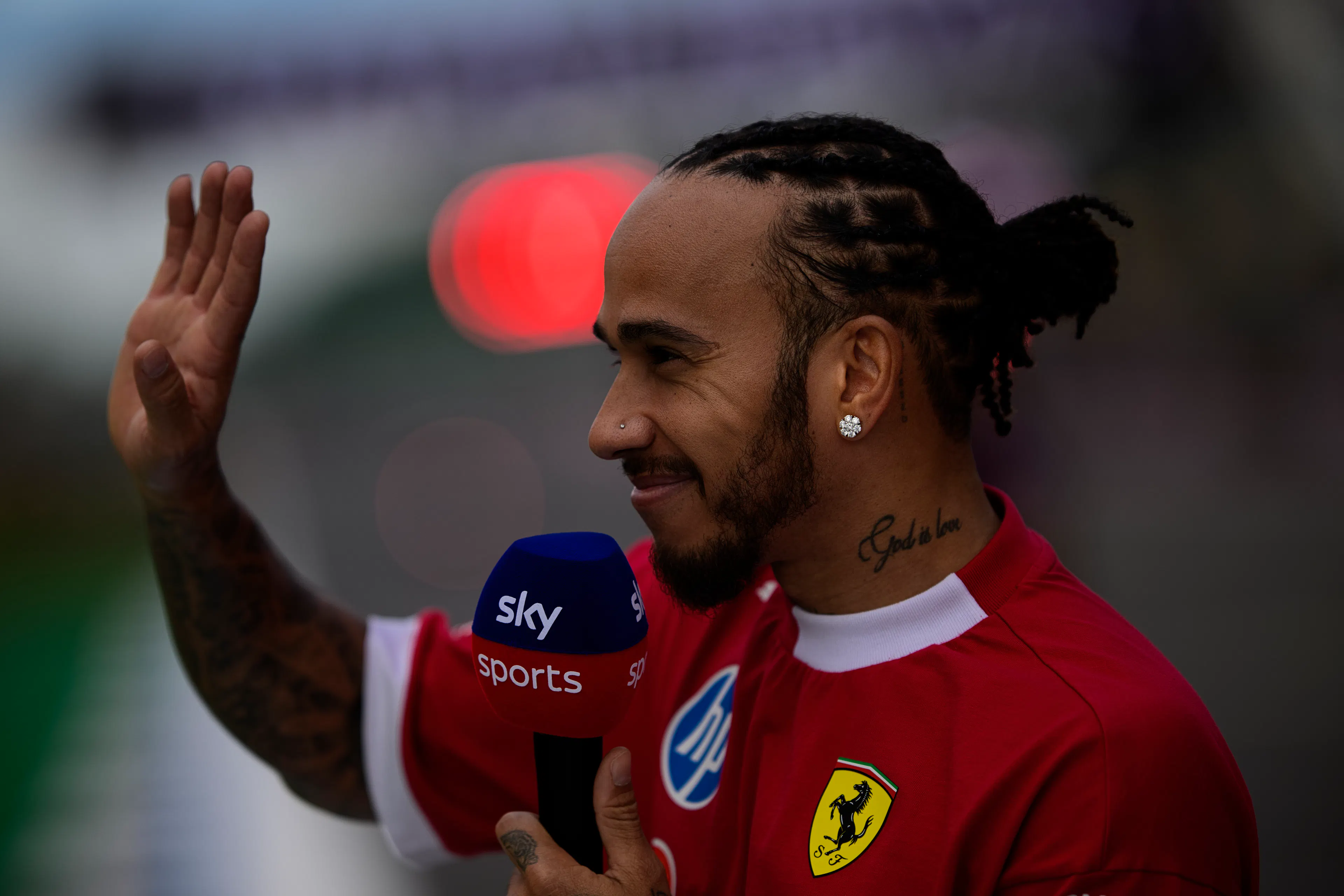 F1 person waving and holding a microphone