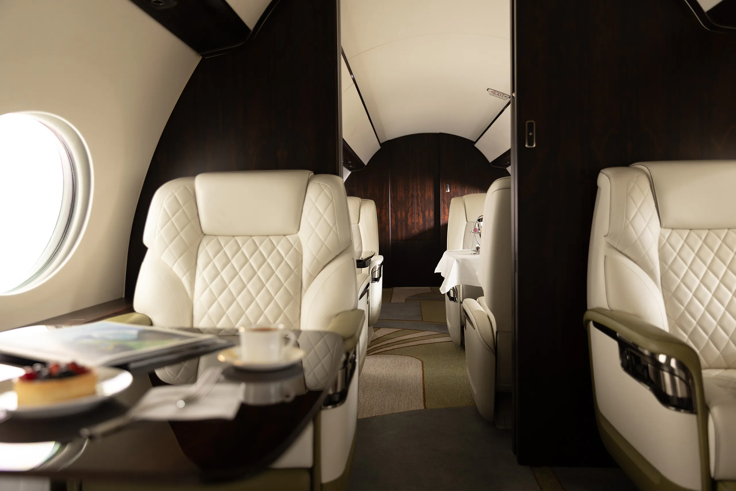 Interior of a Gulfstream G700, seats and a magazine on a table