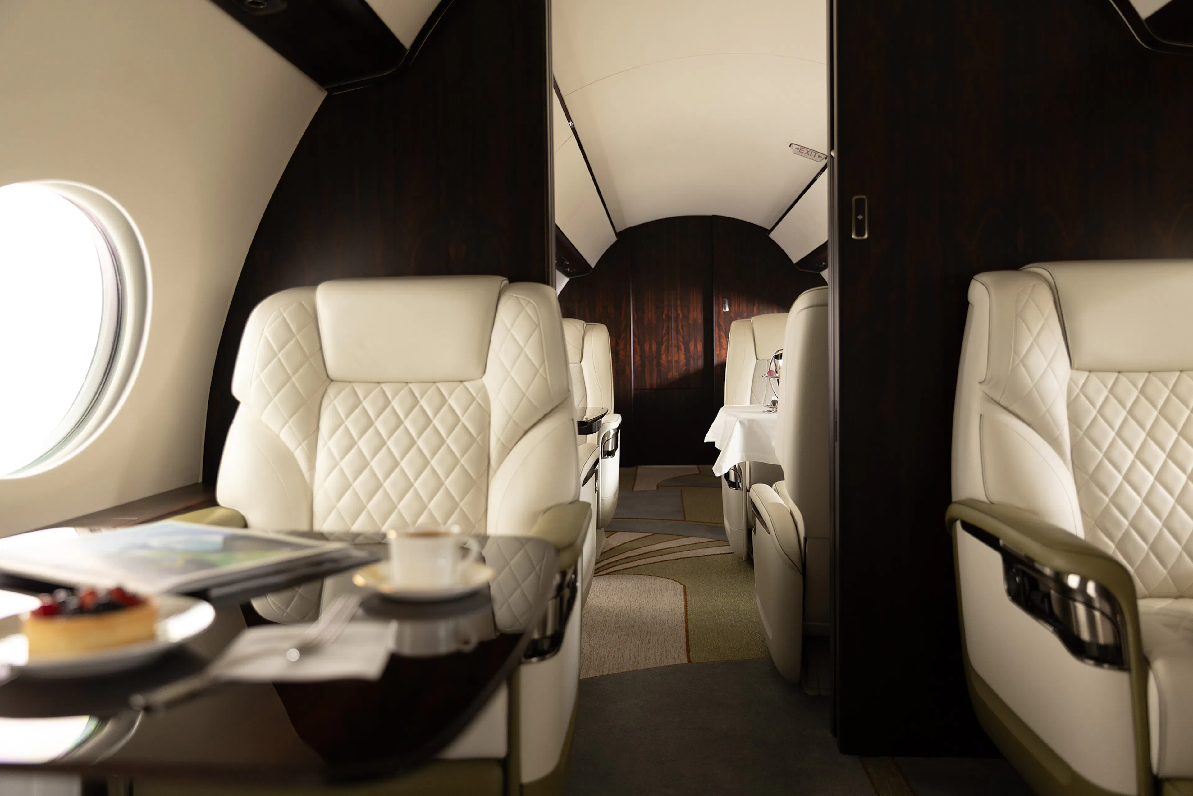 Interior of a Gulfstream G700, seats and a magazine on a table