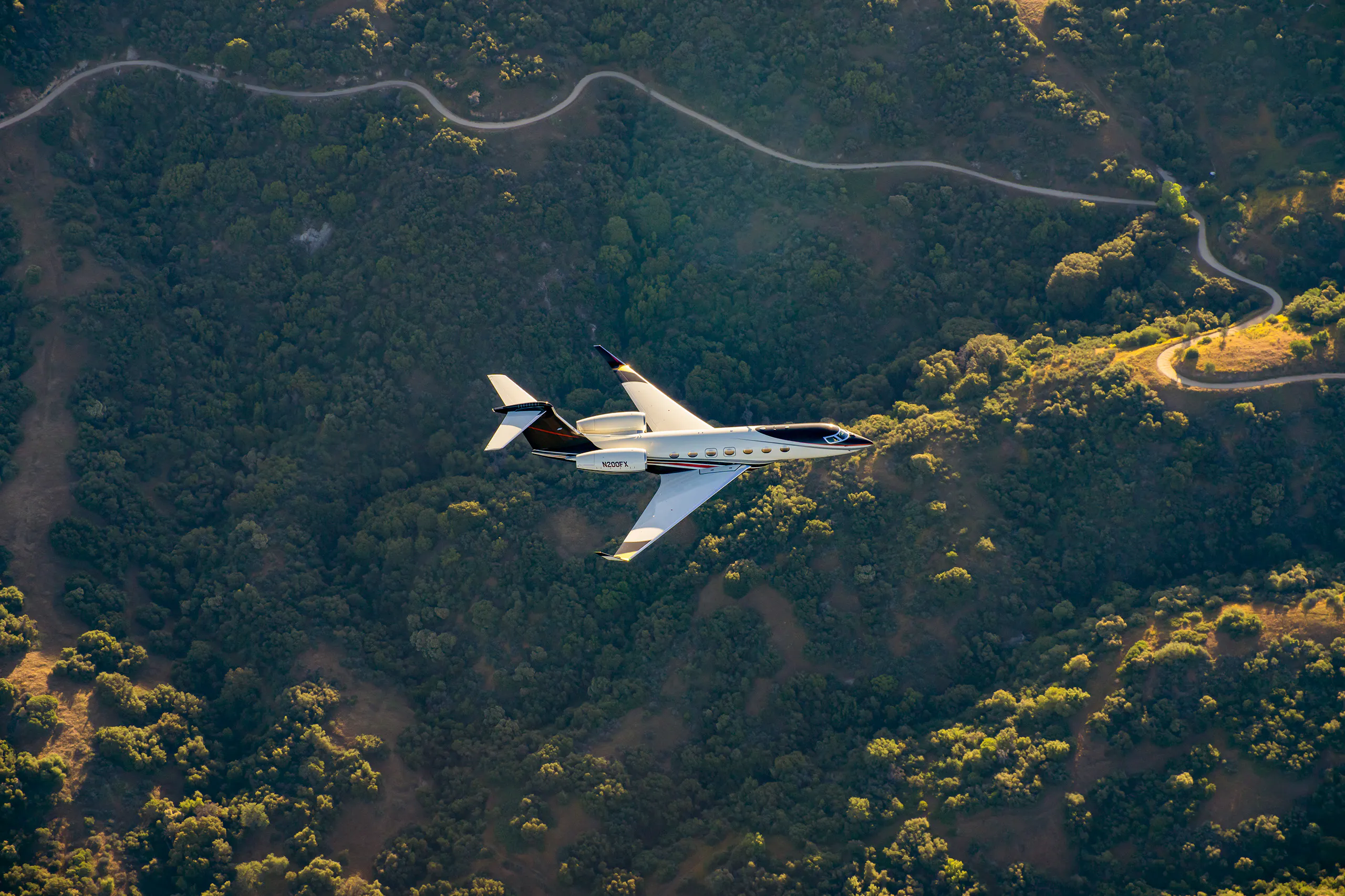 A Gulfstream G500 flying over hilly terrain