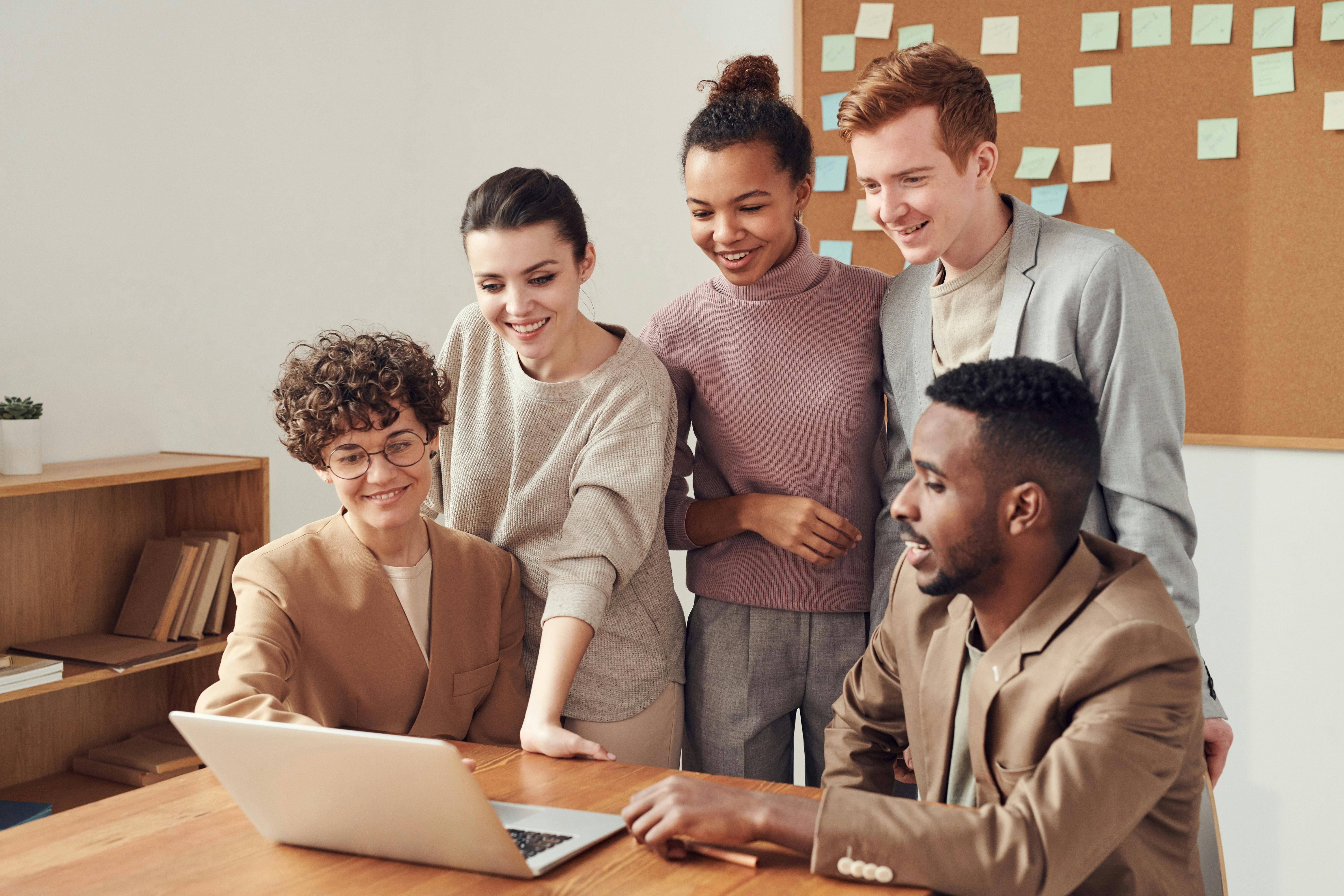 Fünf Menschen vor einem Laptop Fünf Menschen vor einem Laptop