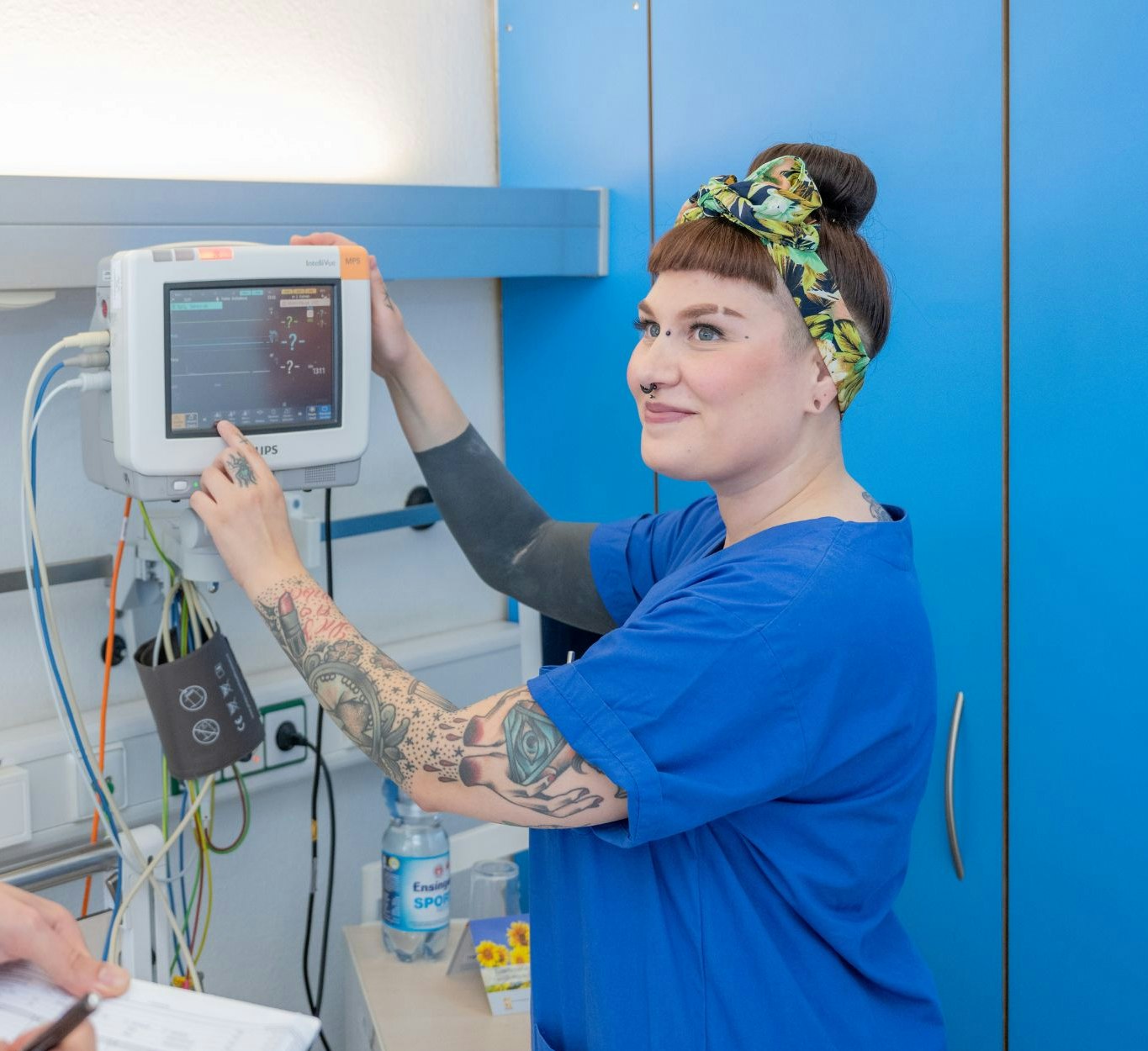 Nurse in blue coat operates surveillance screen