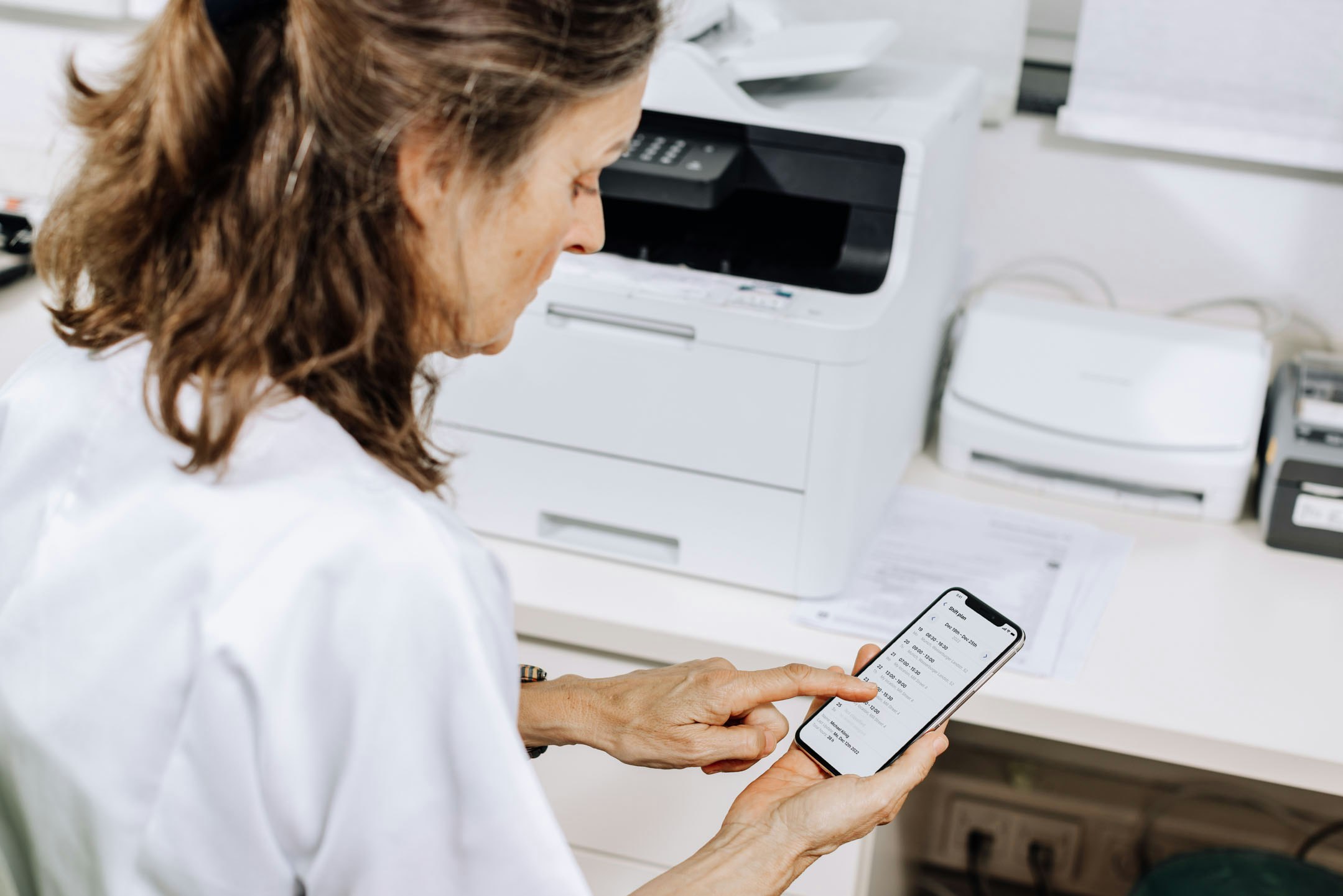 Doctor holds mobile phone with shift plan