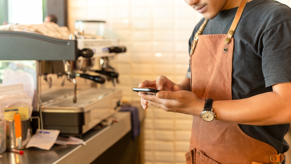 Hospitality frontline worker using a smartphone