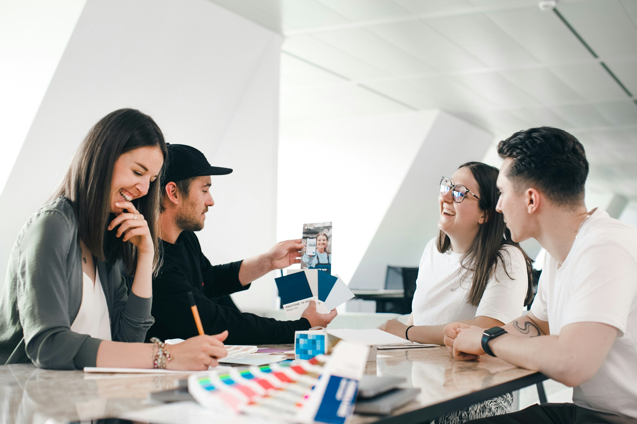 Four people laughing at a table during a workshop