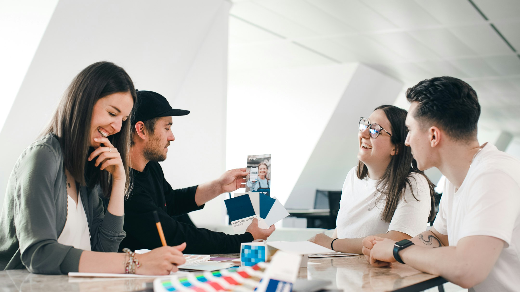 Four people laughing at a table during a workshop